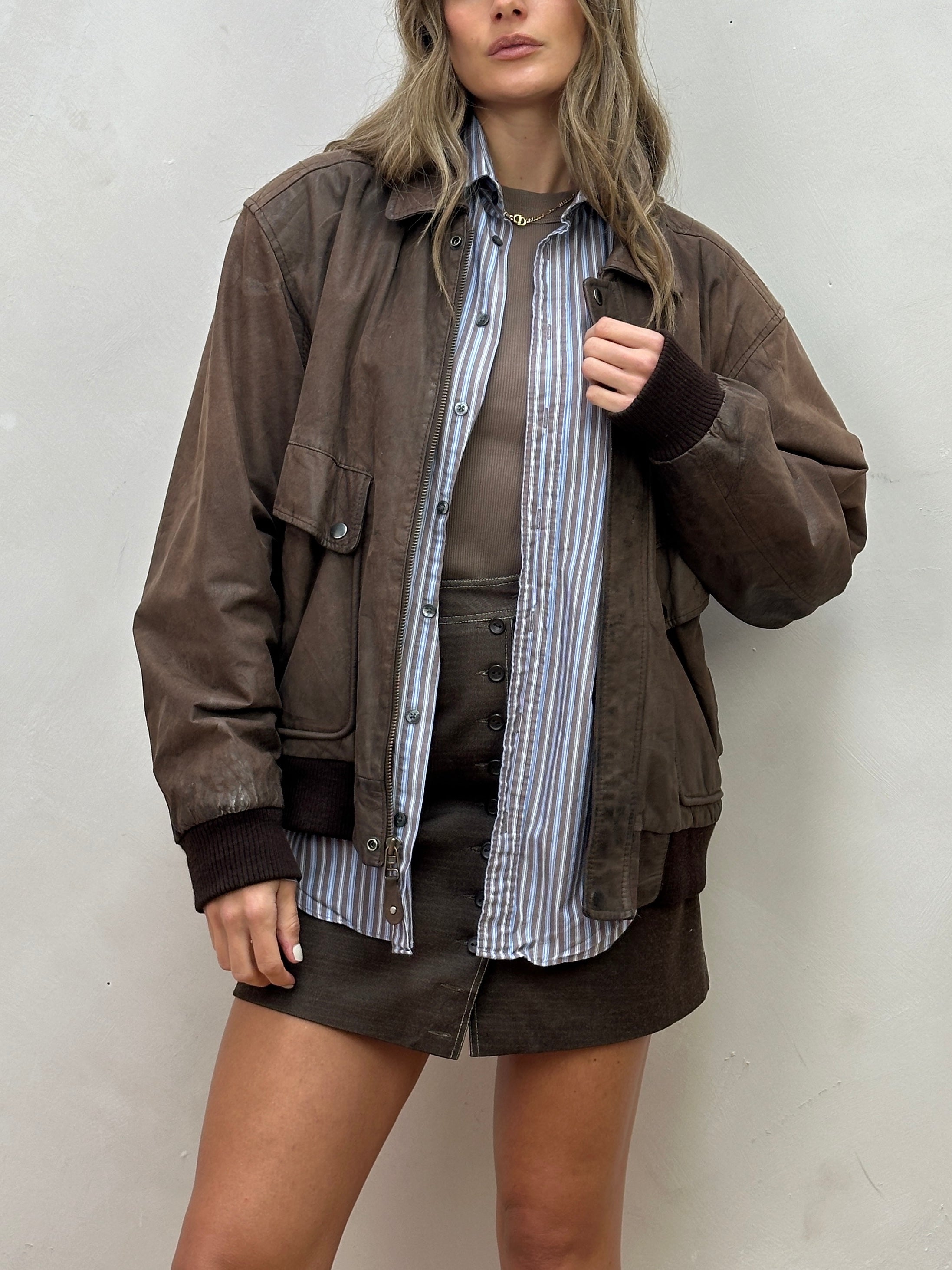 Vintage distressed leather bomber jacket in size large, featuring rugged style and classic design.