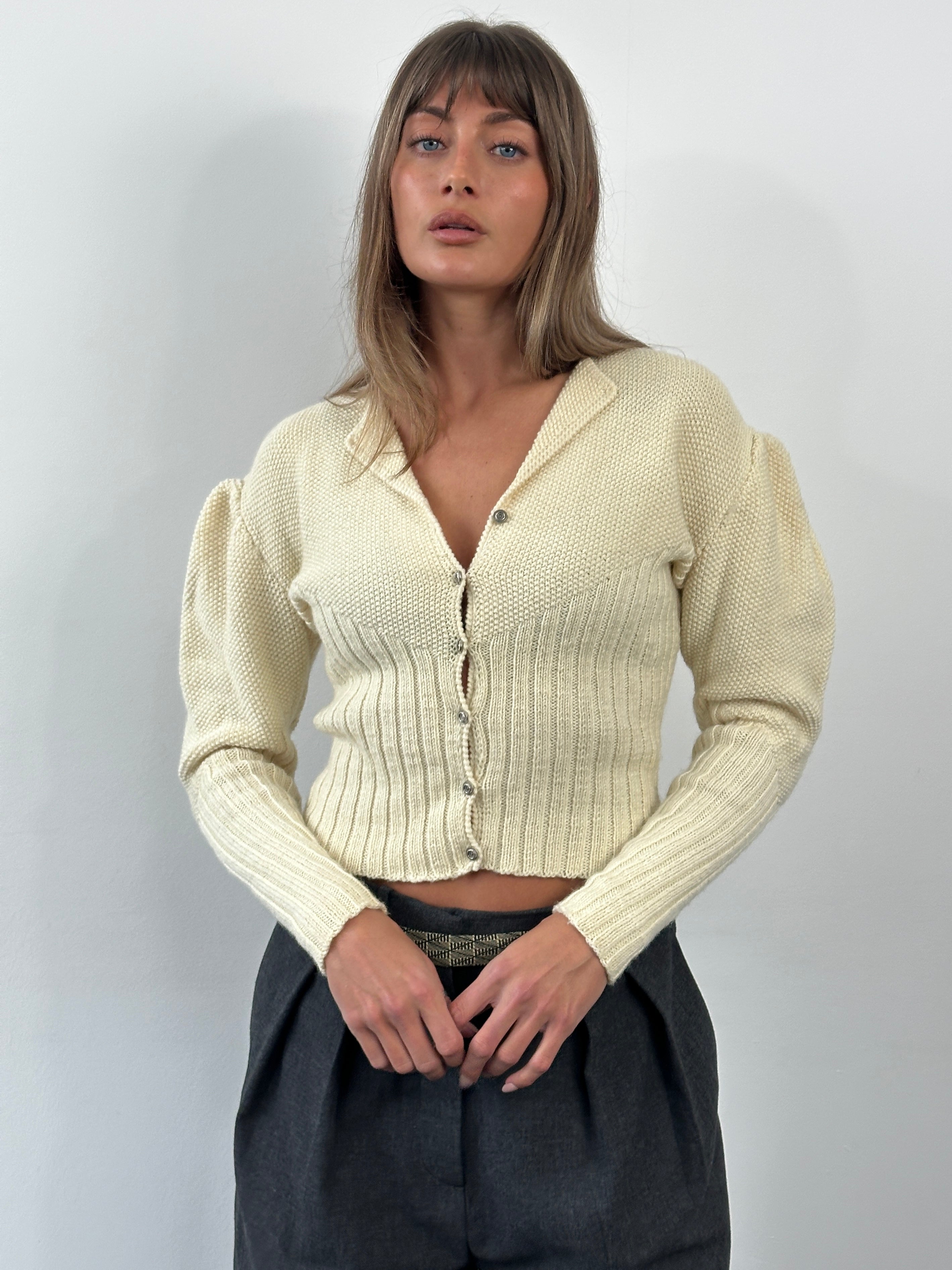 Vintage 1980s wool puff sleeve knitted cardigan in beige with ribbed cuffs and collar, displayed on a hanger.