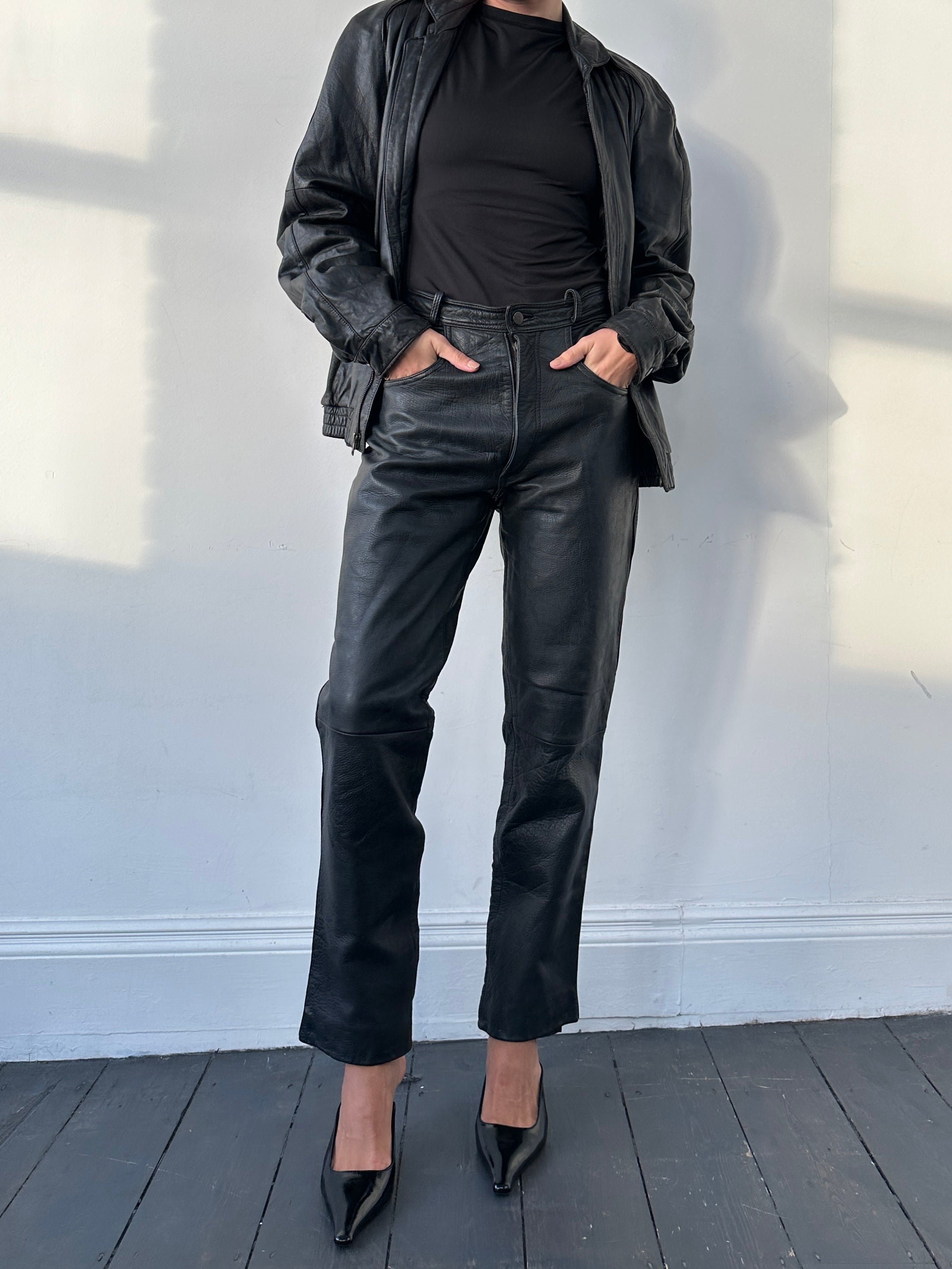 Vintage high waisted straight leg leather trousers in W28 laid flat showing the front and classic design details.