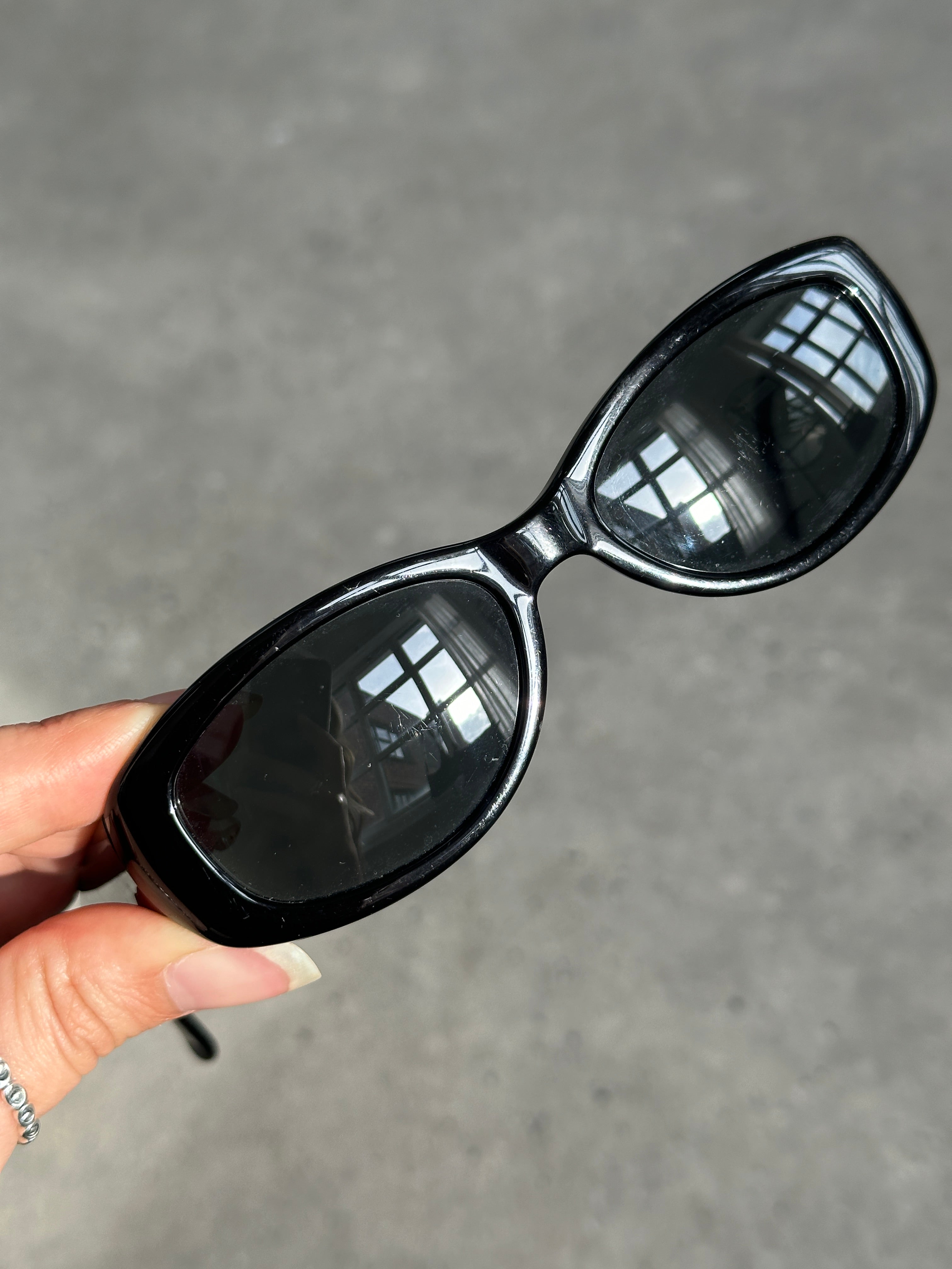 Emporio Armani oval sunglasses with dark tinted lenses and sleek black frames, stylish and modern eyewear.