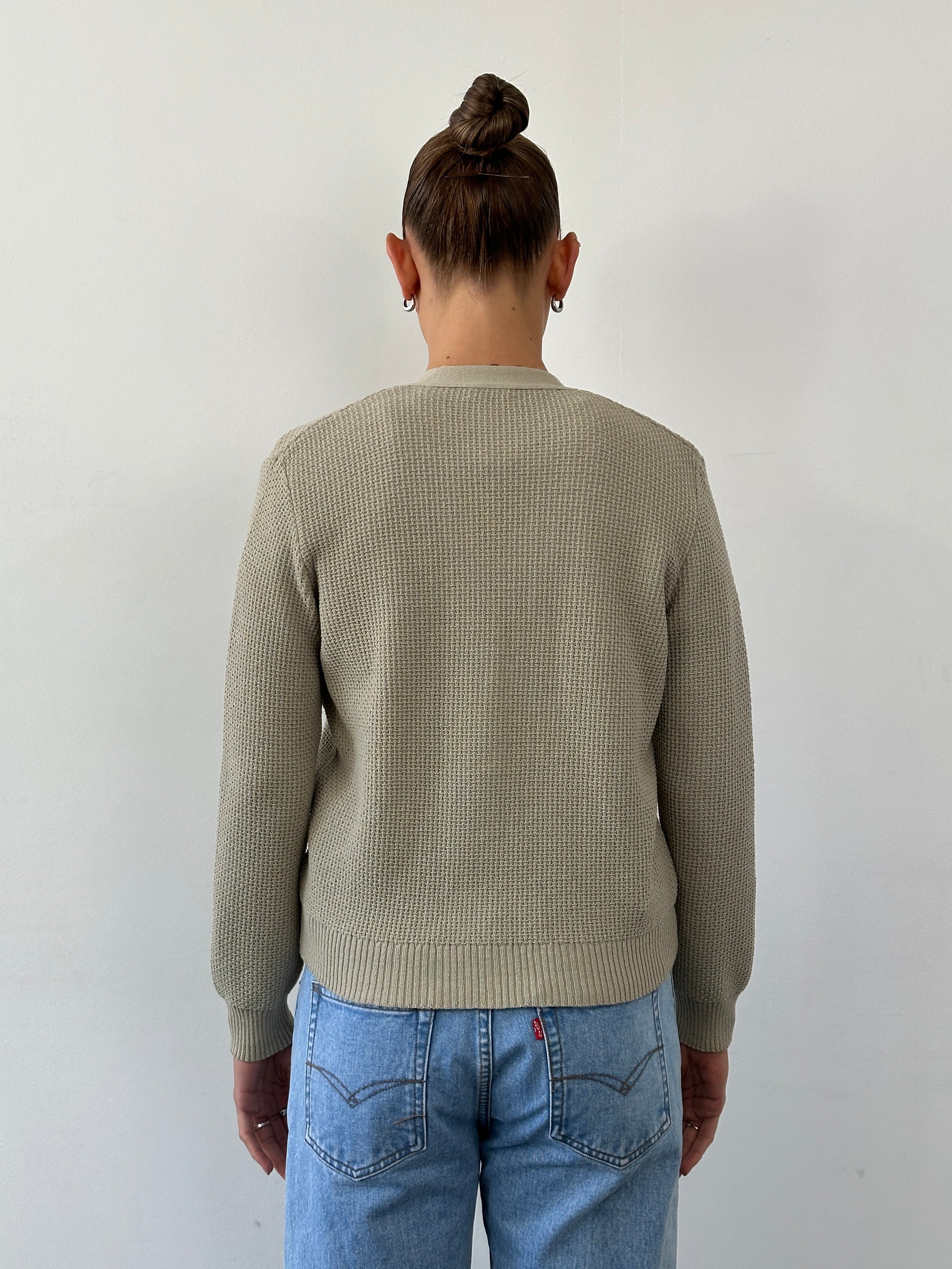 Vintage pure wool knitted cardigan in size small, featuring a classic button-up design with ribbed cuffs and collar.