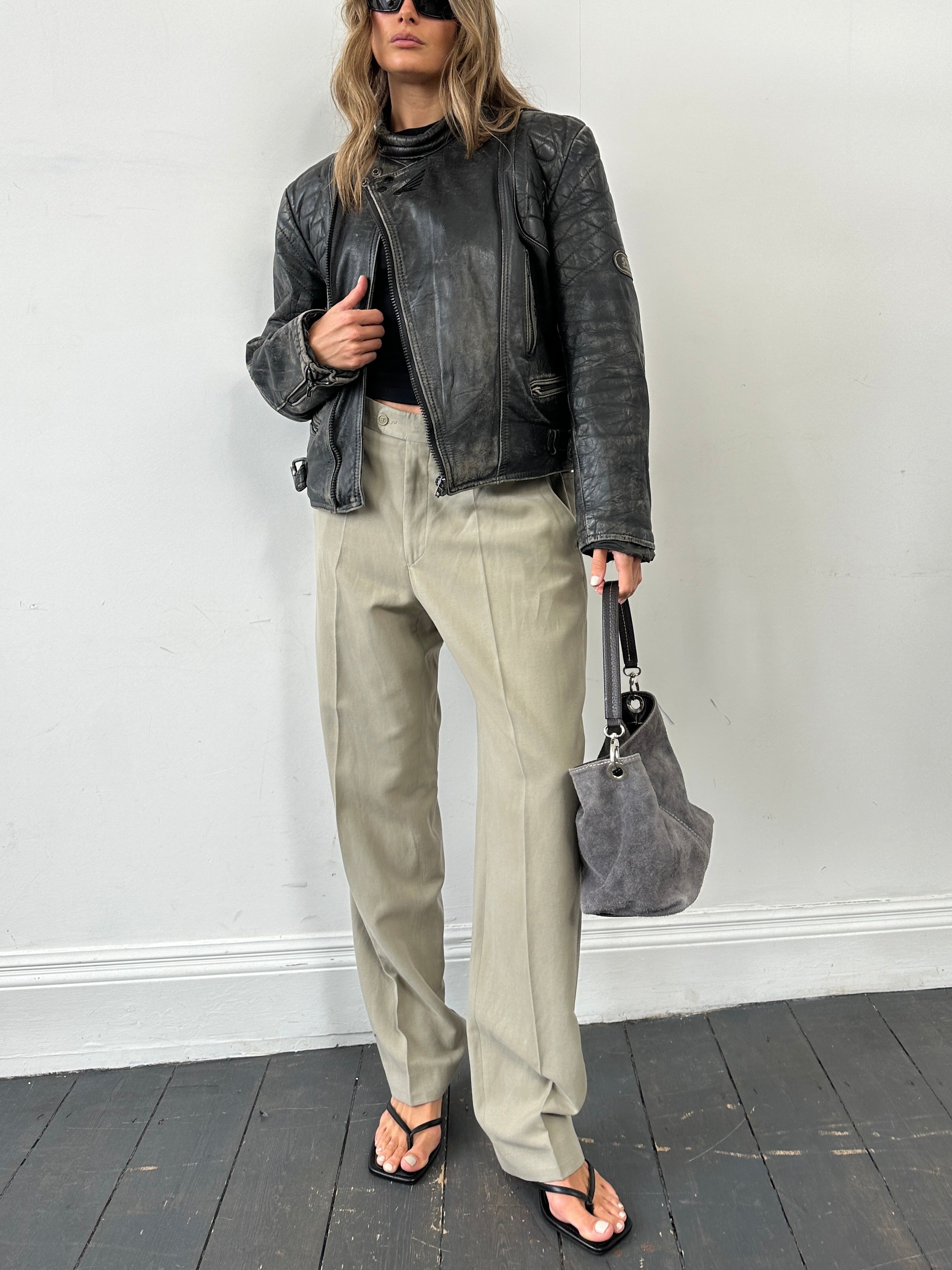 Vintage brand distressed leather motorcycle jacket in size M/L, with rugged texture and classic design, shown on a model.