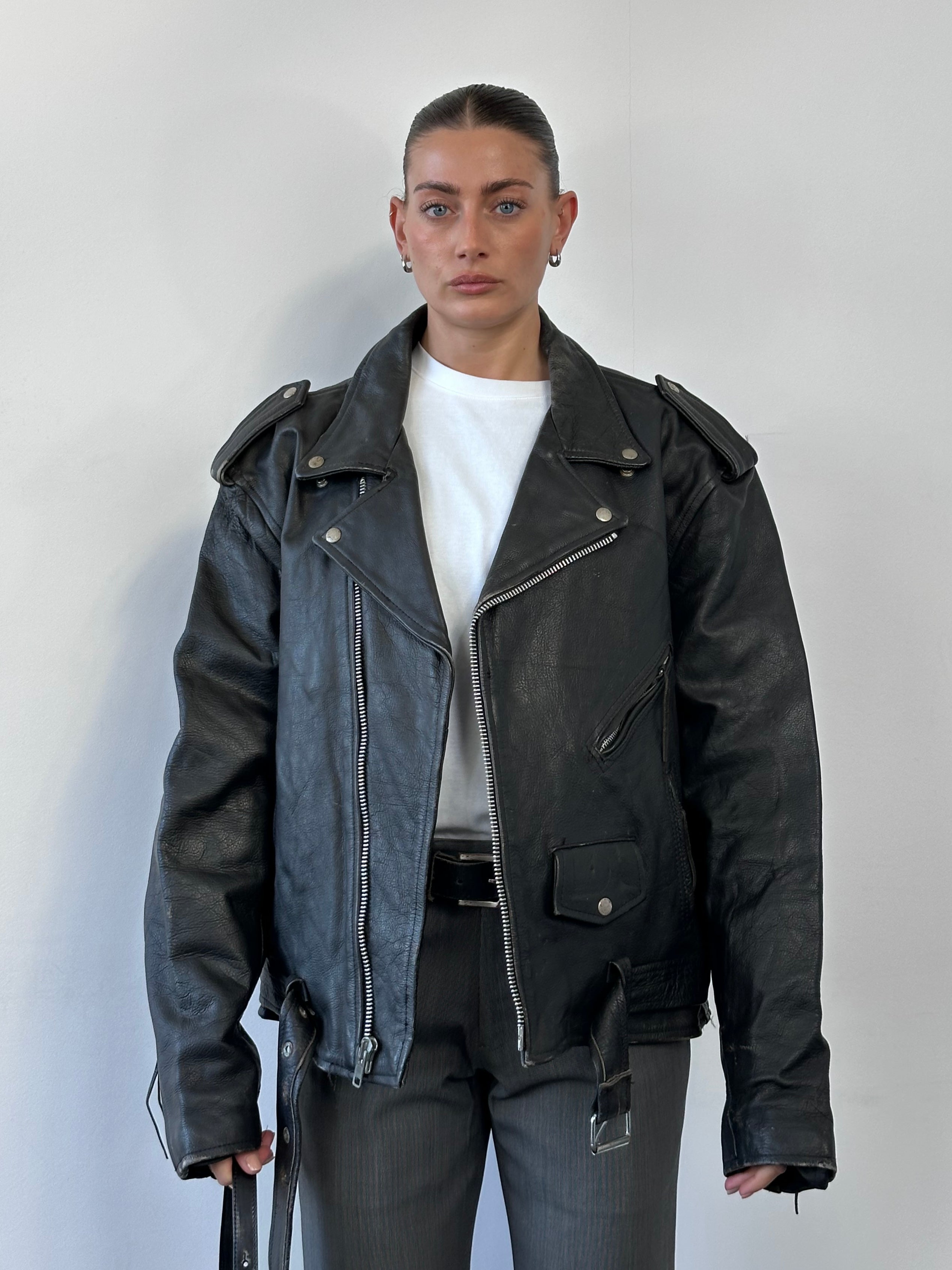 Vintage leather biker jacket in XL size, featuring classic design with shoulder epaulets and front zipper detailing.