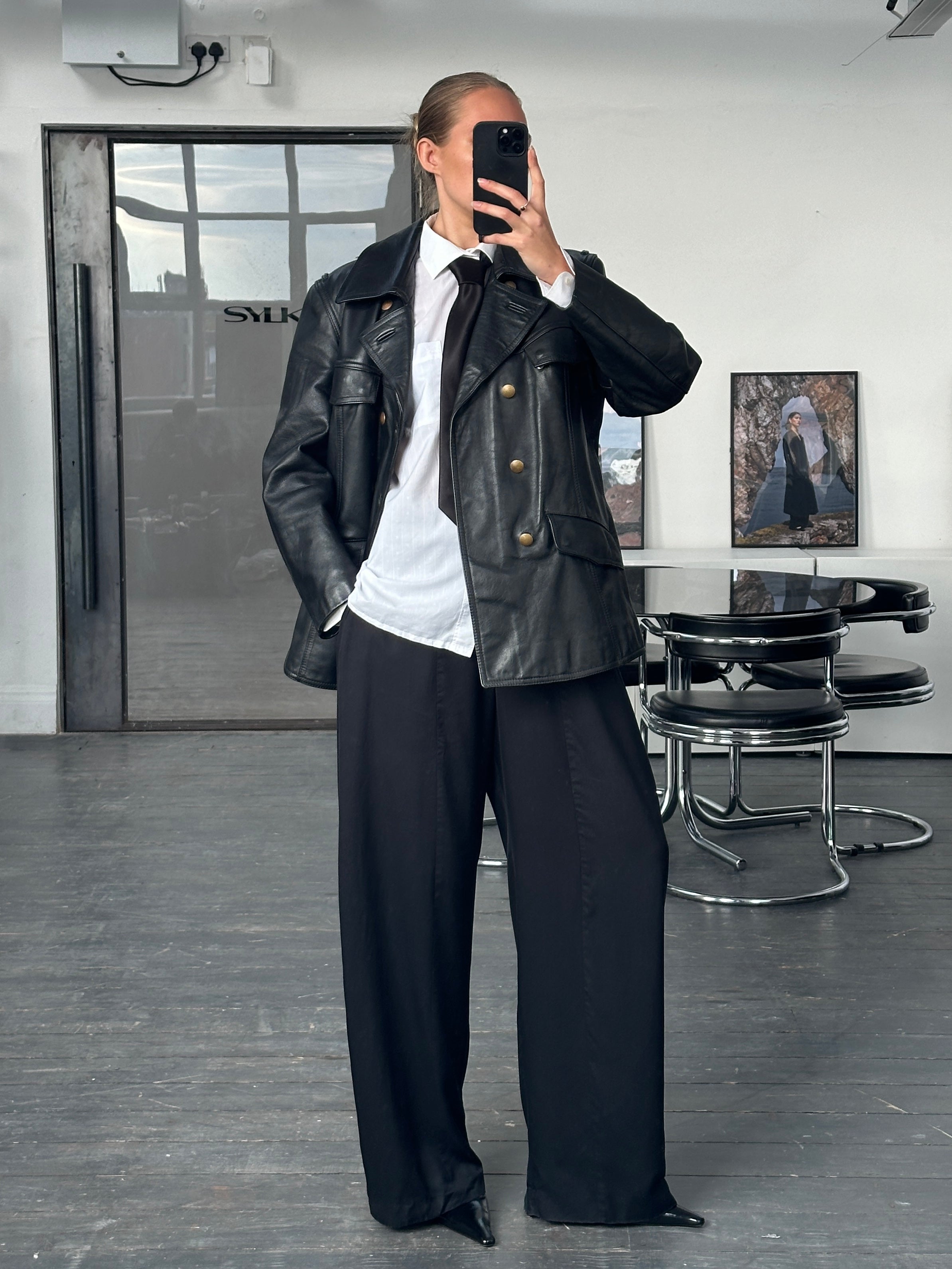 Vintage 1980s double-breasted military leather jacket in black, featuring classic design and structured fit, size M/L.