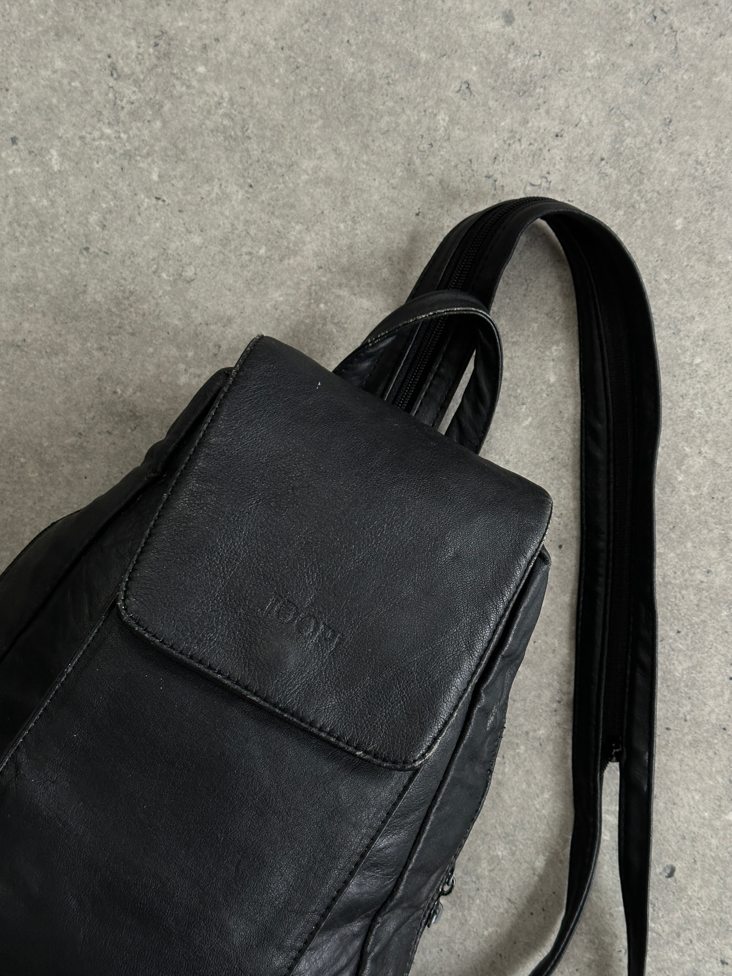Vintage faux leather rucksack bag with adjustable straps and front pocket, stylish and durable.