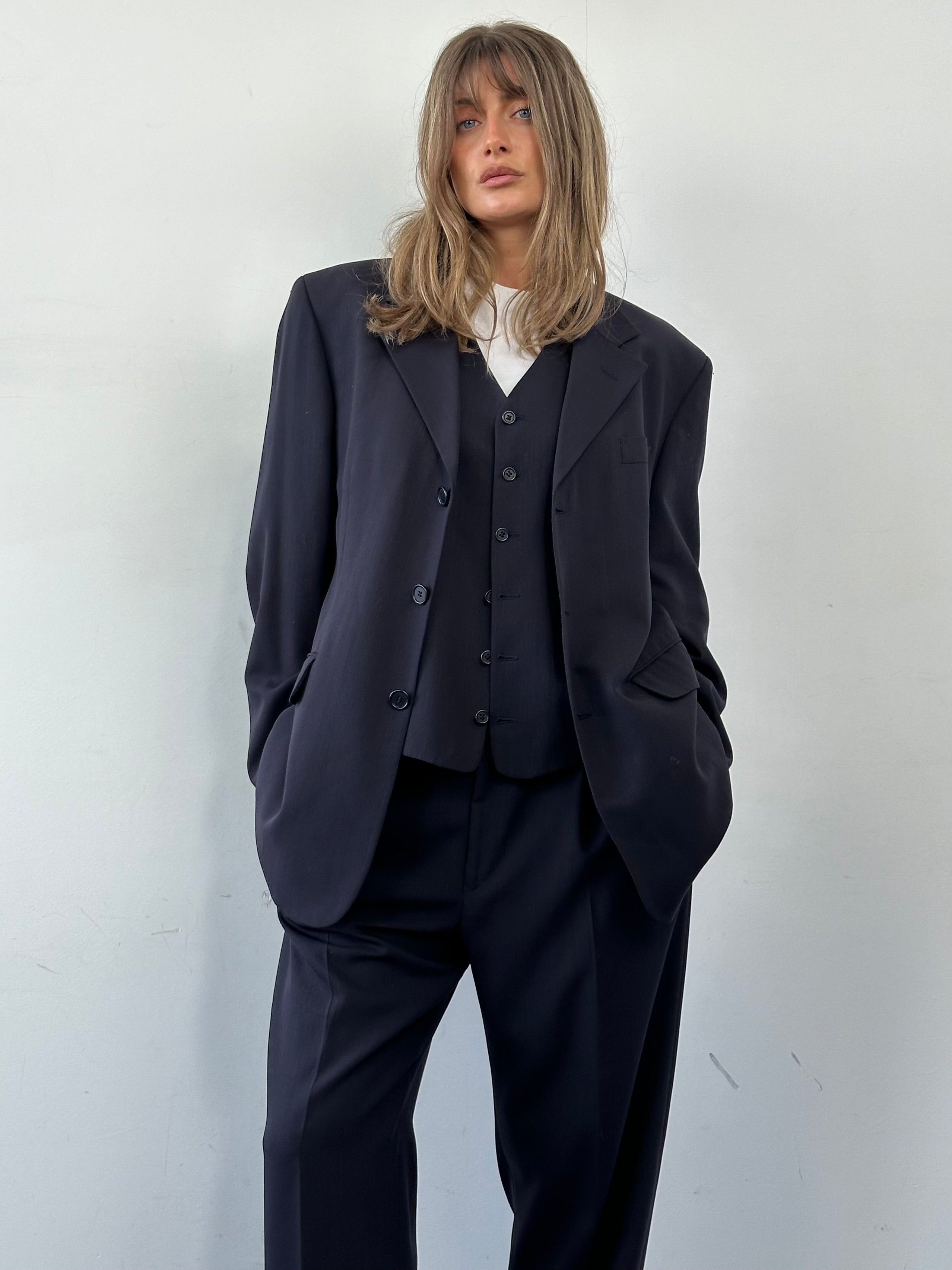 Yves Saint Laurent Pour Homme pure wool three-piece suit in size 44R/W36, displayed on a hanger with jacket, vest, and trousers.