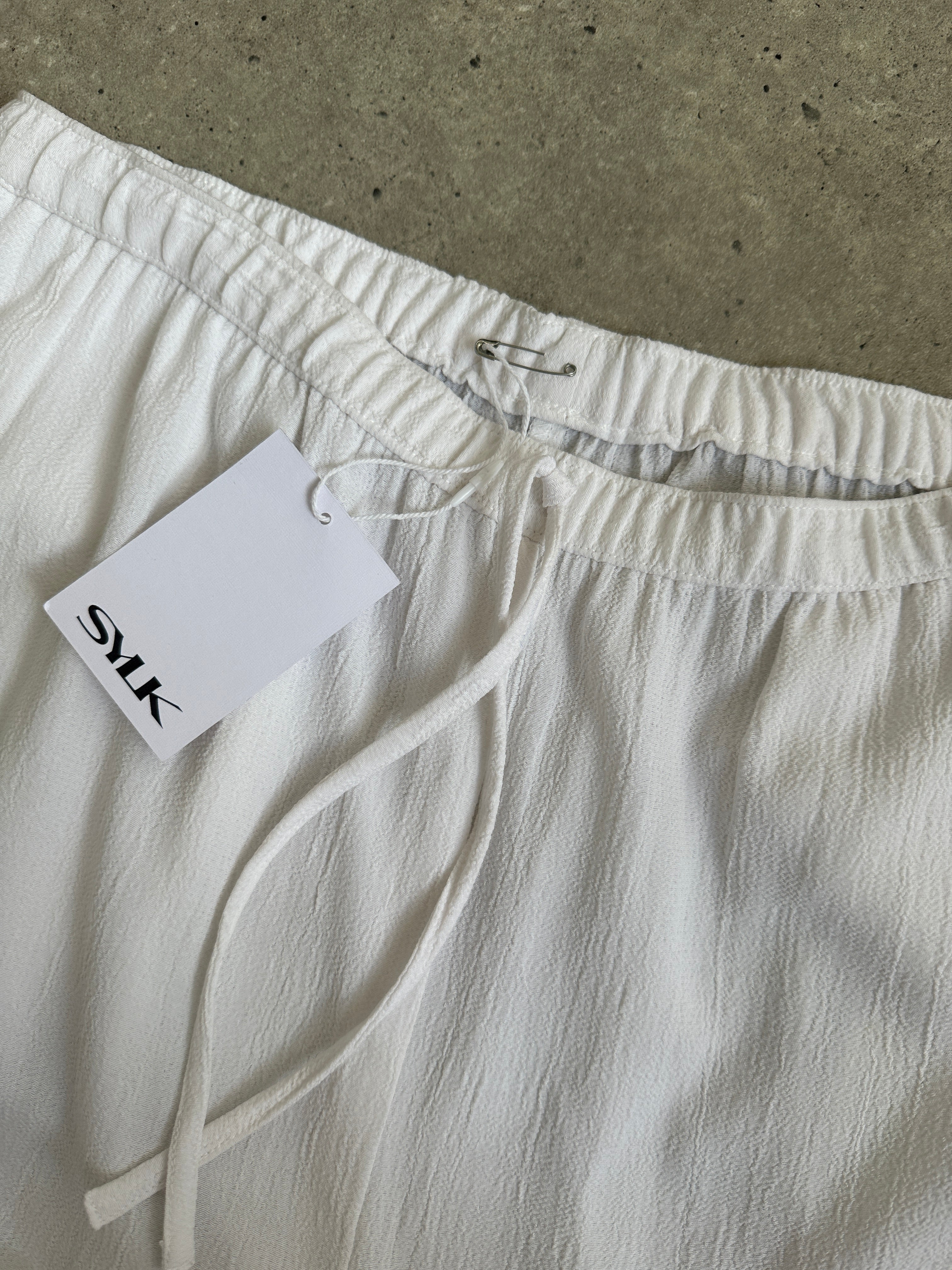 Vintage wide-leg pull-on trousers with crinkle effect, elasticated waist, available in sizes W28-32, casual and stylish fit.