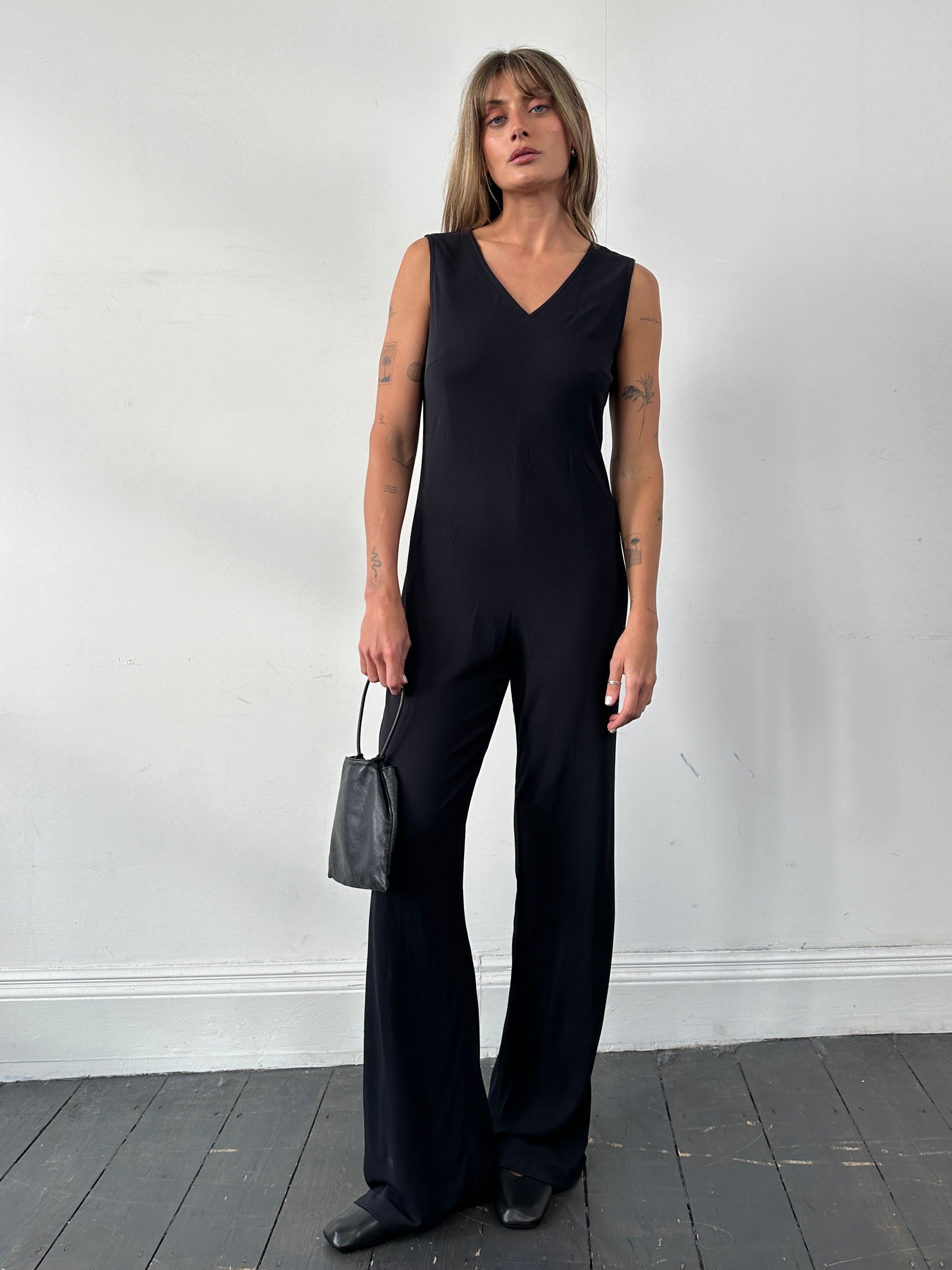Vintage 80s V-neck stretch jumpsuit in size S/M with sleeveless design and fitted waist, displayed on a hanger.