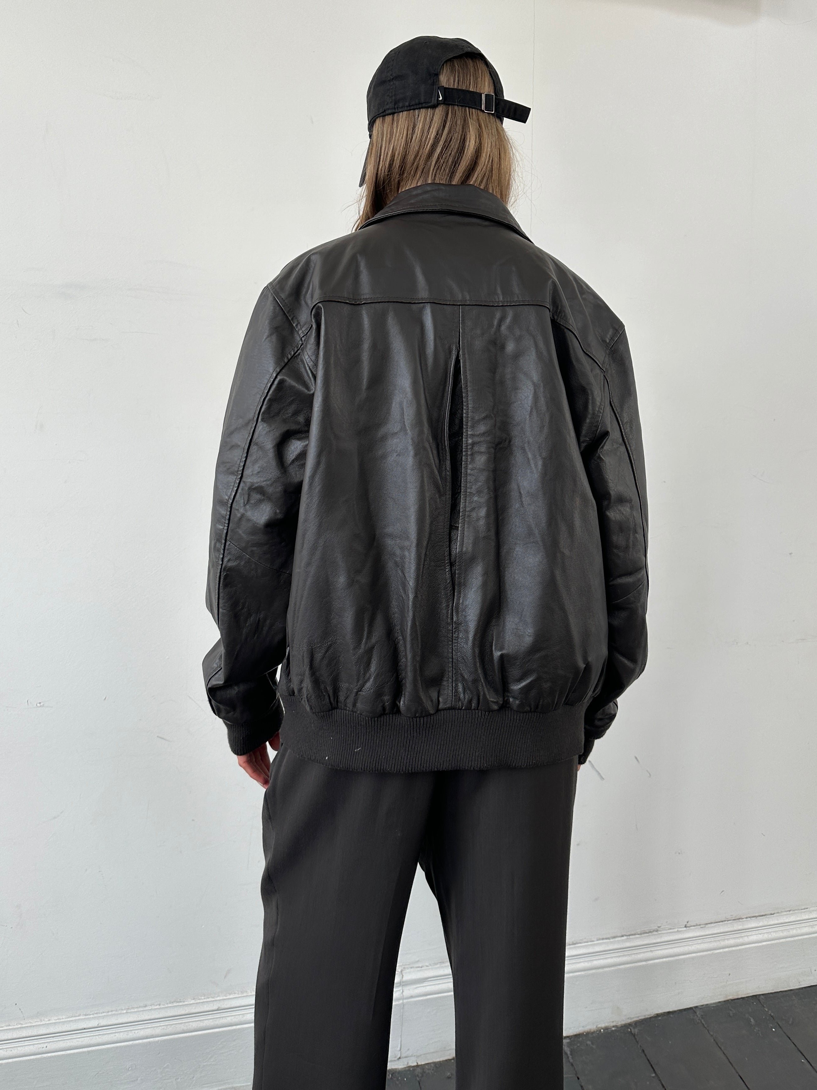 Vintage smooth leather bomber jacket in size large, featuring classic design and detailed stitching on a neutral background.
