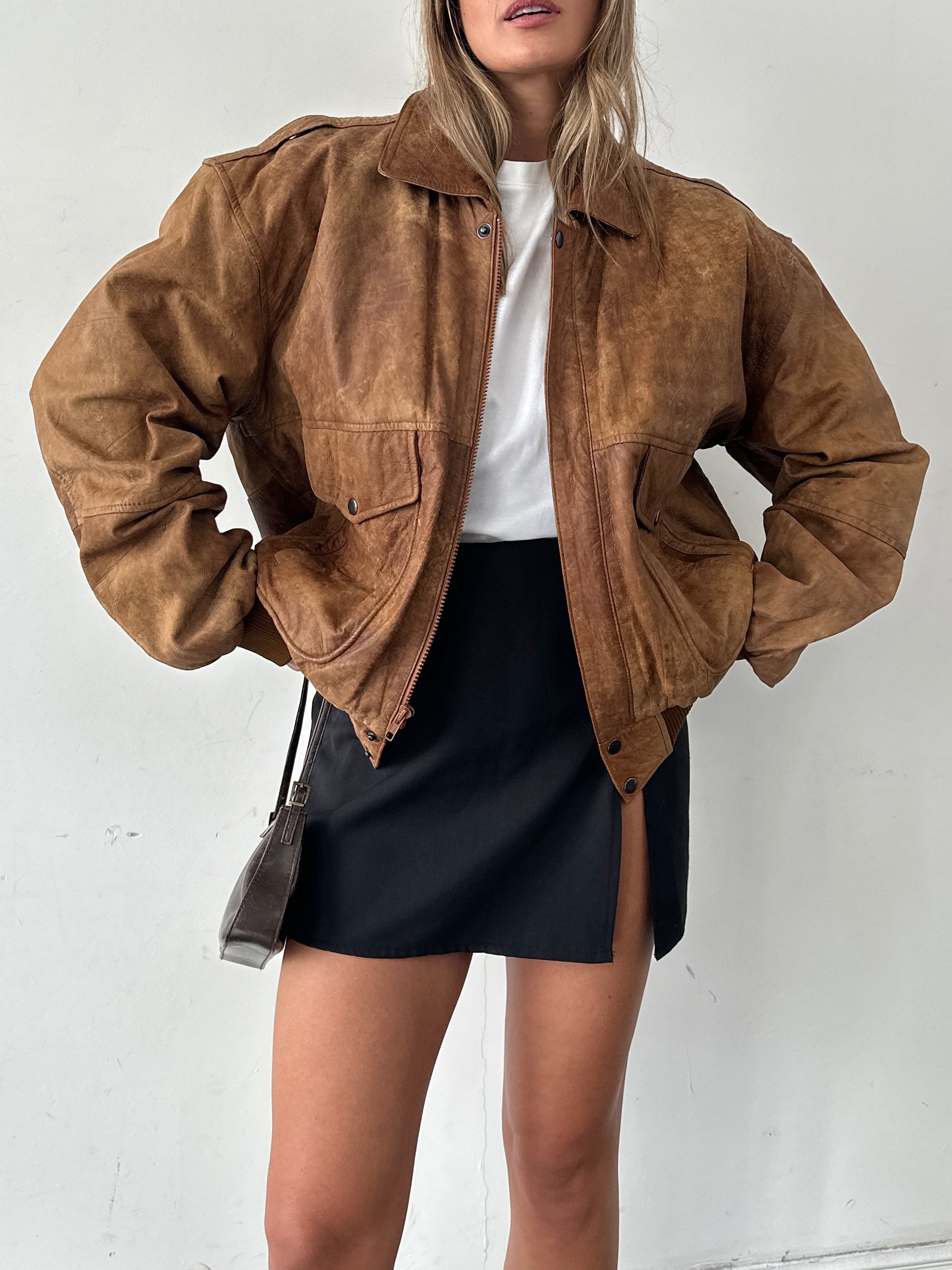 Vintage aged leather bomber jacket in XL size, featuring classic design with worn-in texture and sturdy collar detail.