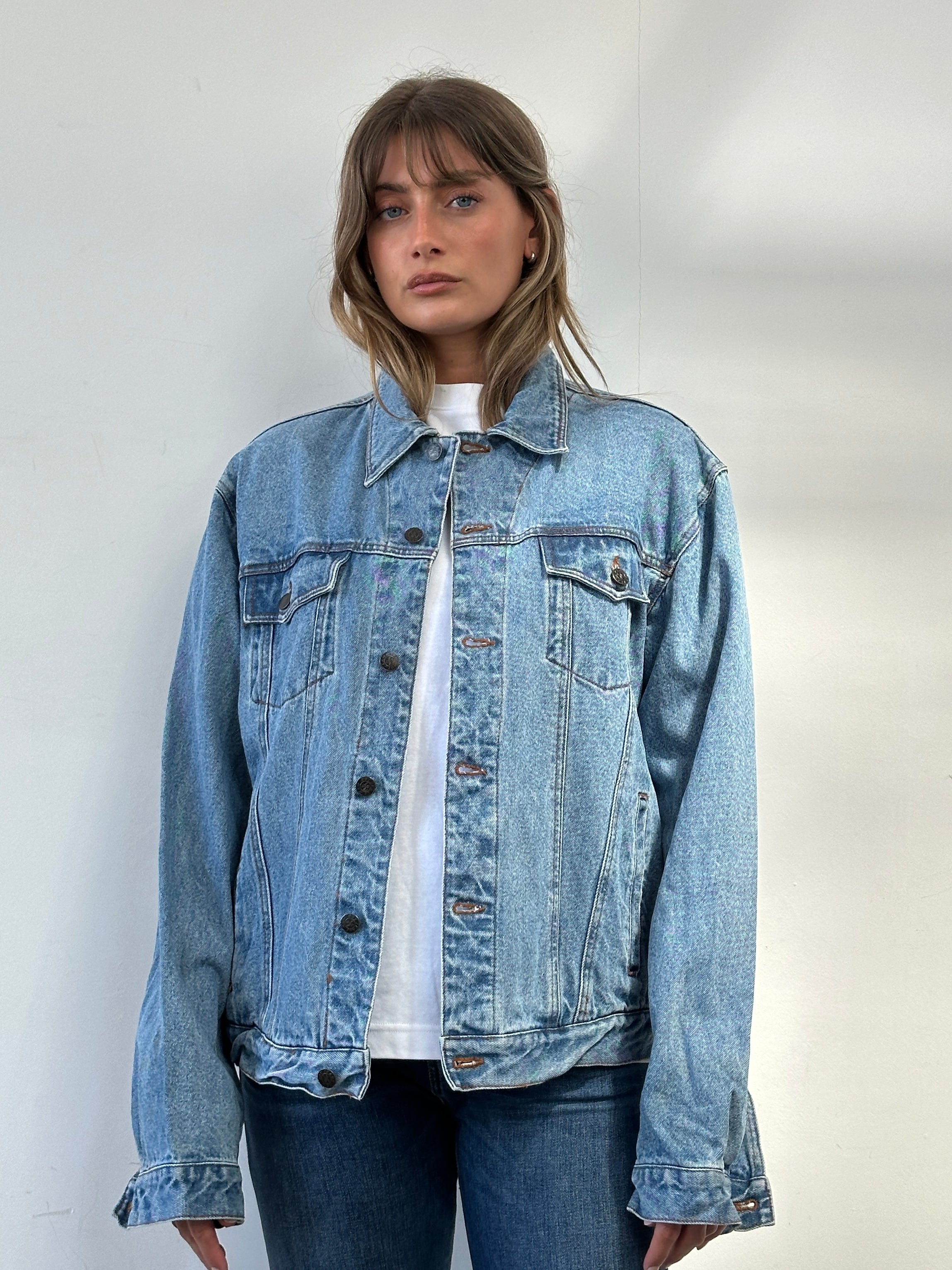 Vintage oversized pure cotton denim jacket, front view showing classic design and faded blue denim fabric.