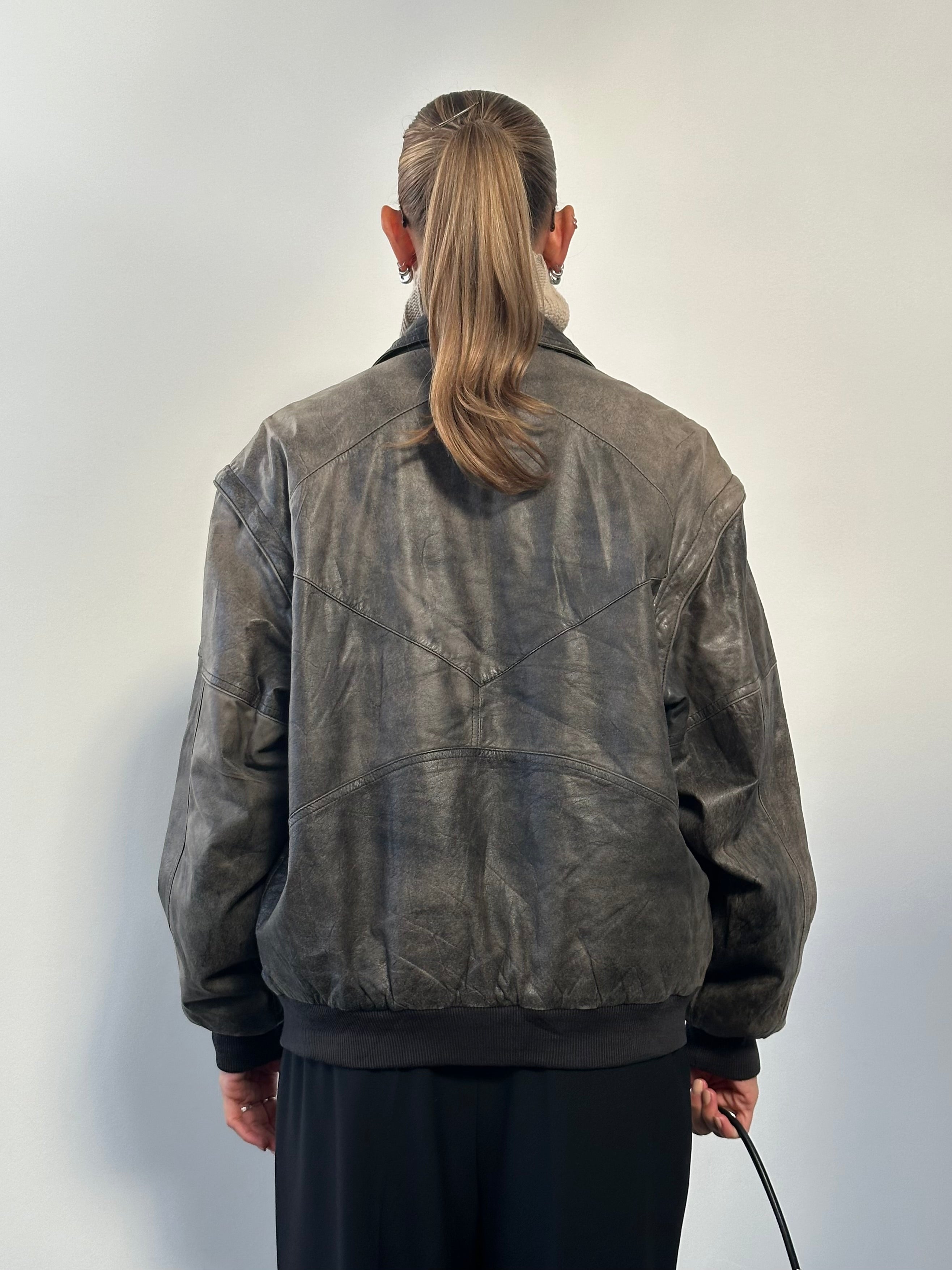 Vintage distressed leather bomber jacket in size L/XL, featuring a rugged, worn-in look with classic style and durable leather material.