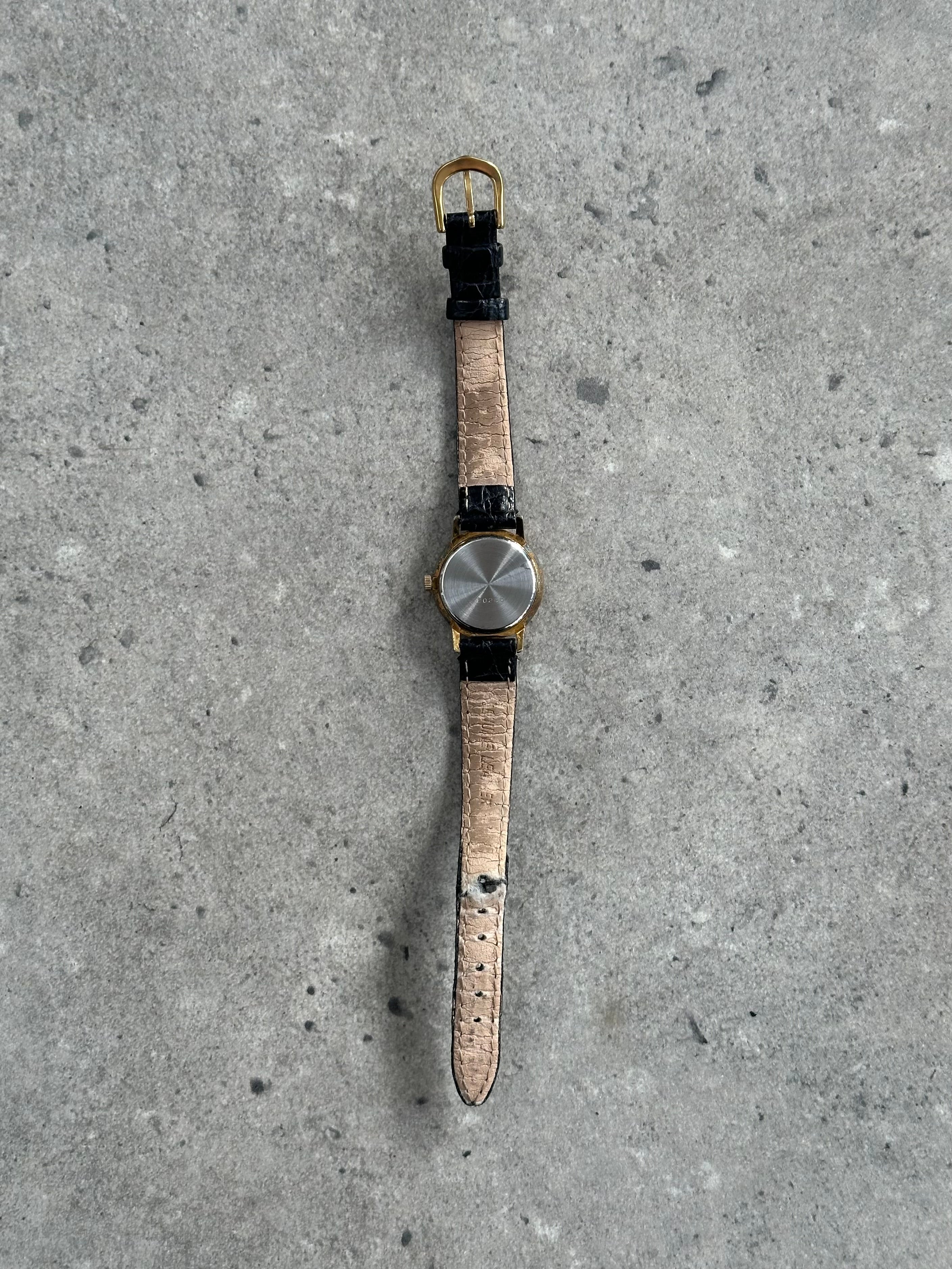 Vintage 1990s round quartz leather watch with a classic design, featuring a leather strap and analog dial.