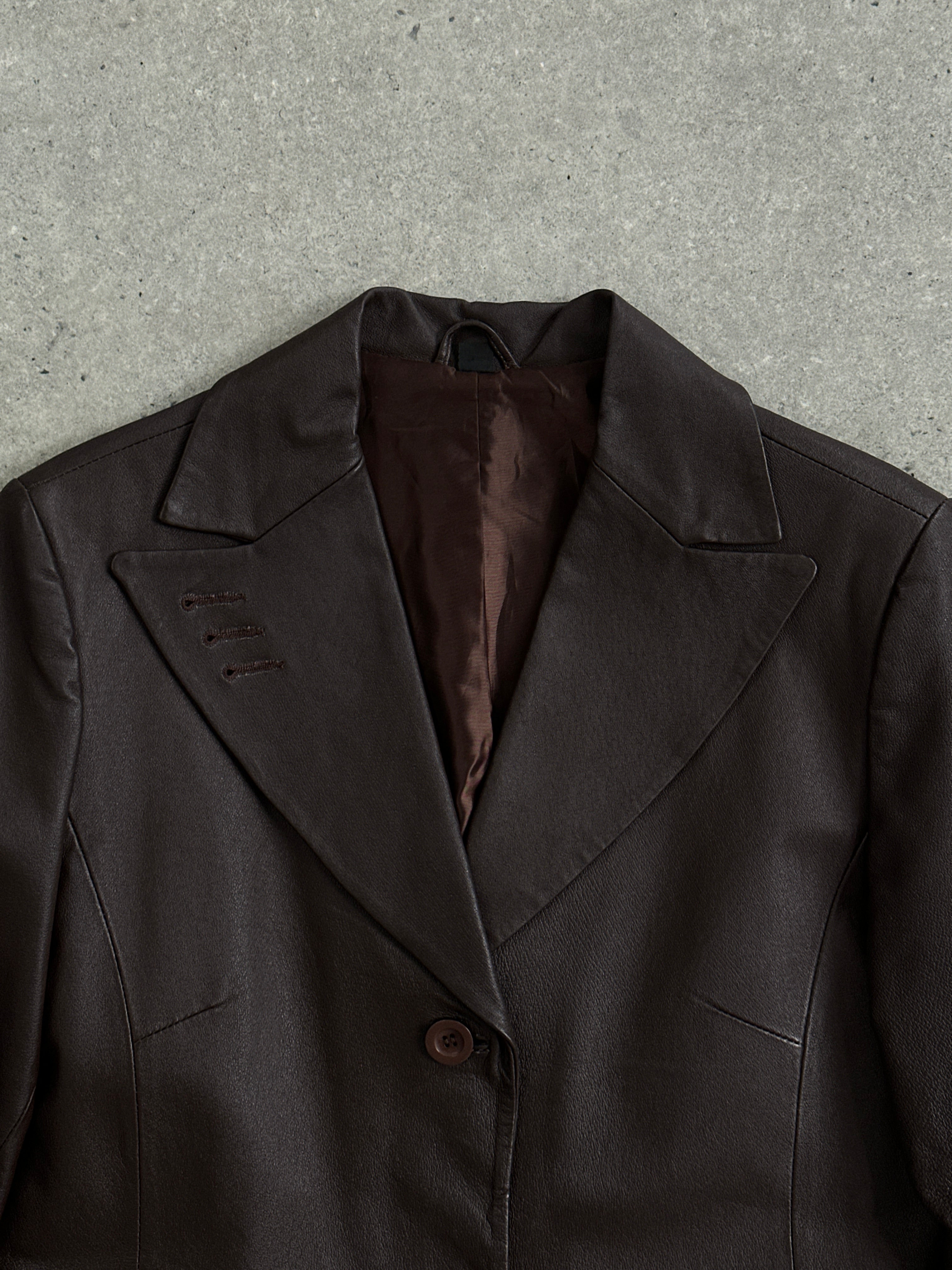 Vintage leather trench coat jacket in size M/L, featuring classic design and detailed craftsmanship, displayed on a hanger.