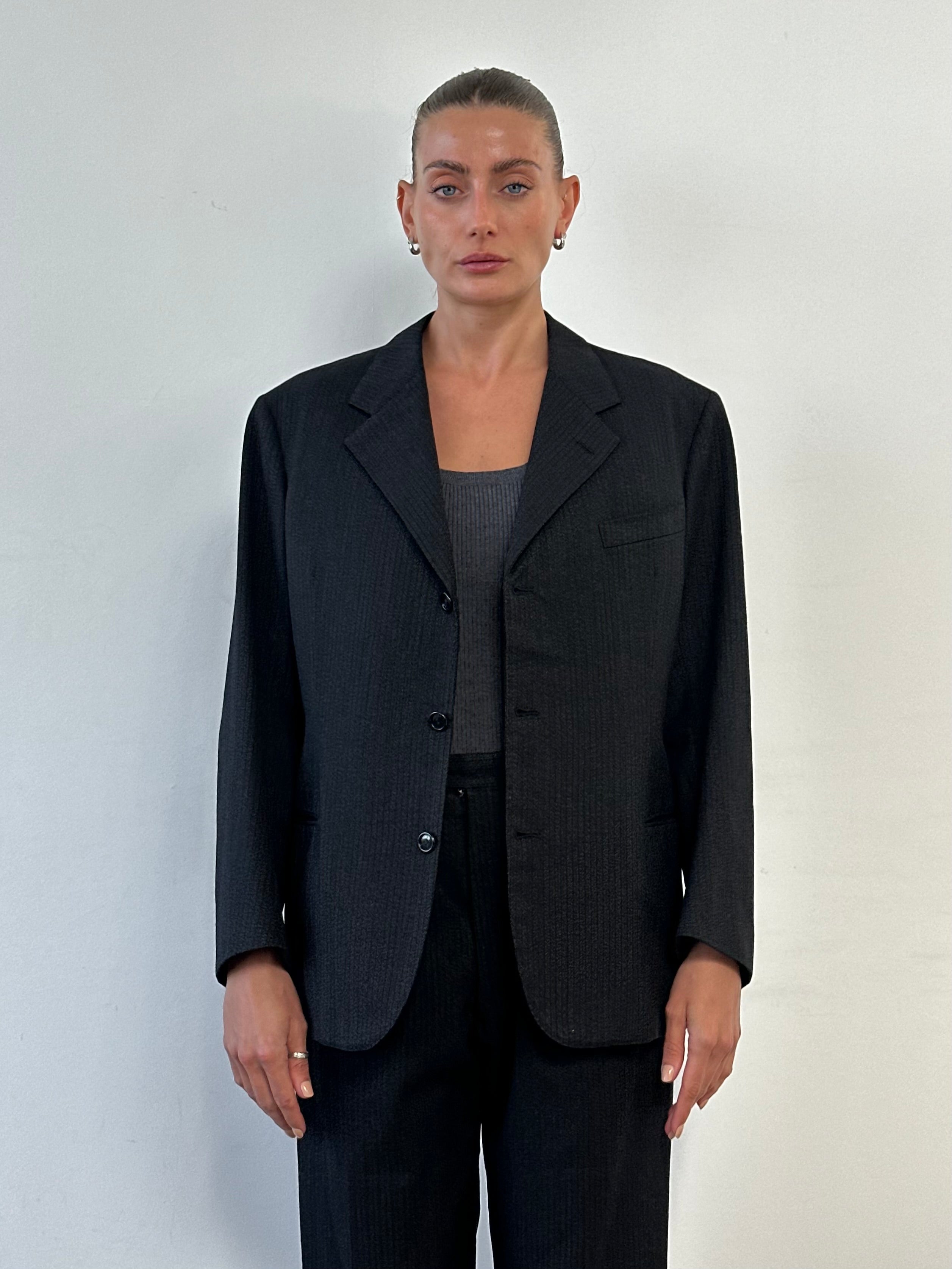 Vintage wool single-breasted suit in size 40R with W28 waist, featuring classic lapels and tailored fit, on a mannequin.