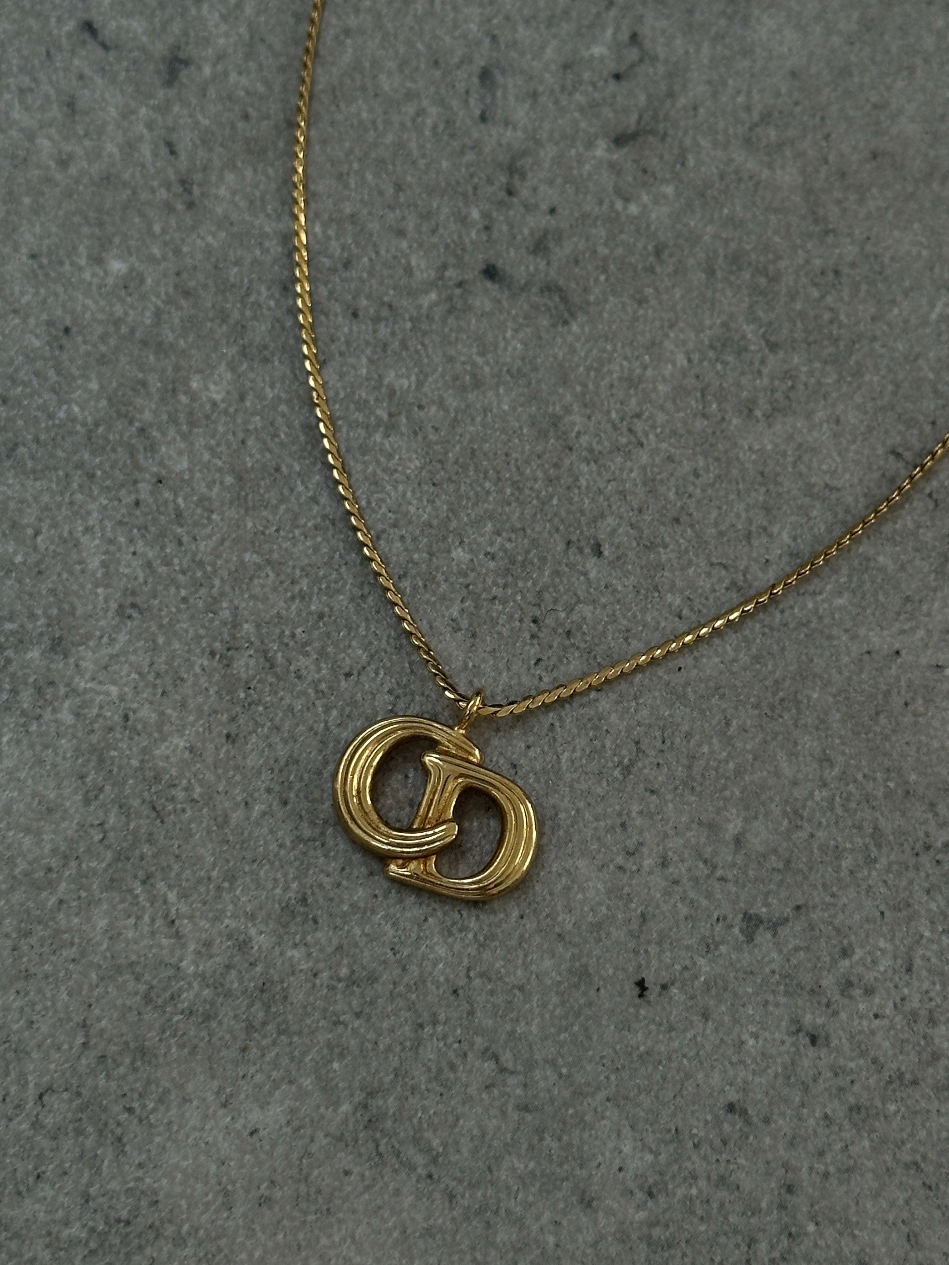 Christian Dior 16-inch gold plated logo pendant necklace showing the iconic Dior logo charm on a delicate chain
