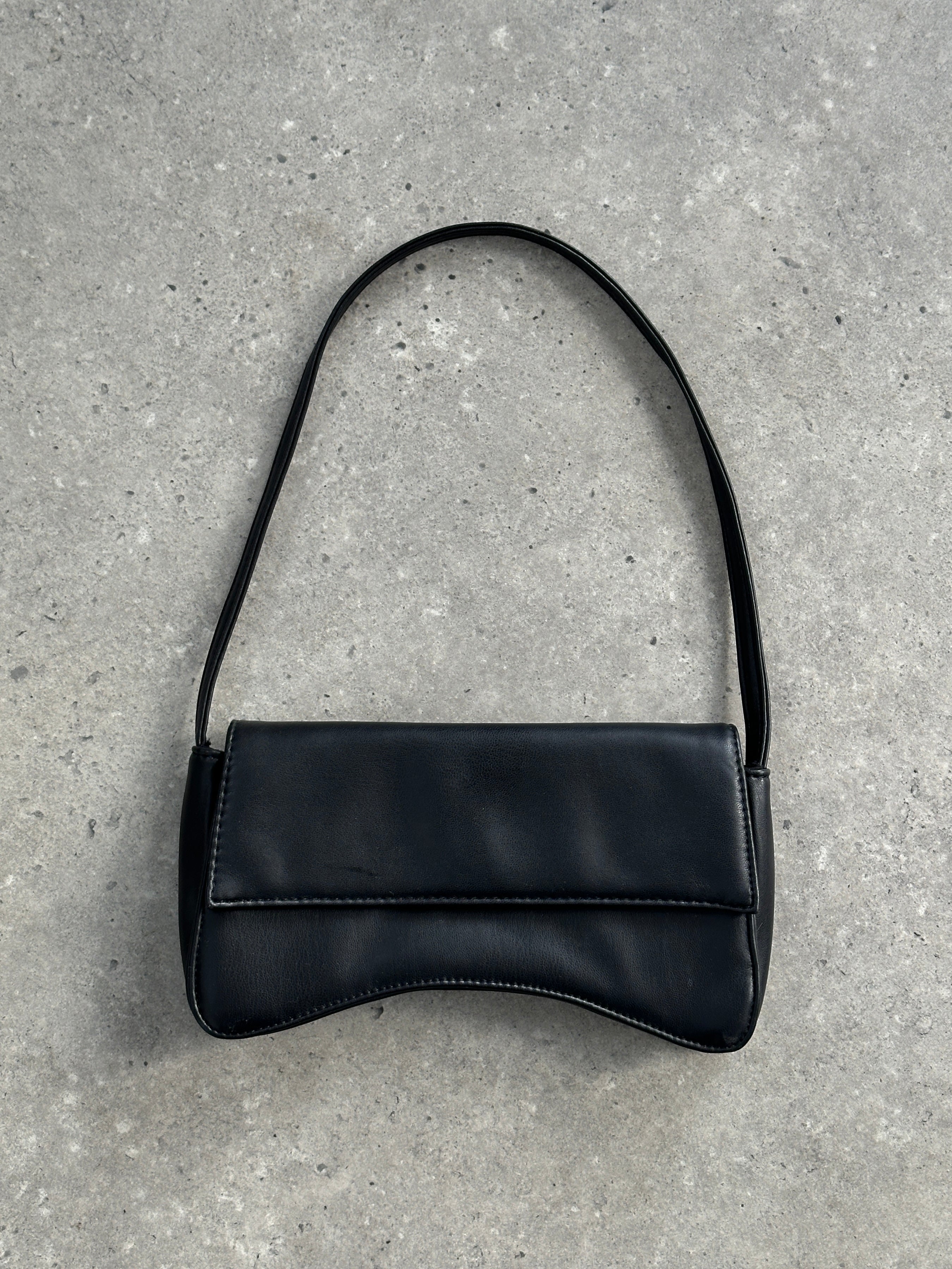 Vintage faux leather shoulder bag with a curved design, featuring a sleek, classic look and adjustable strap.