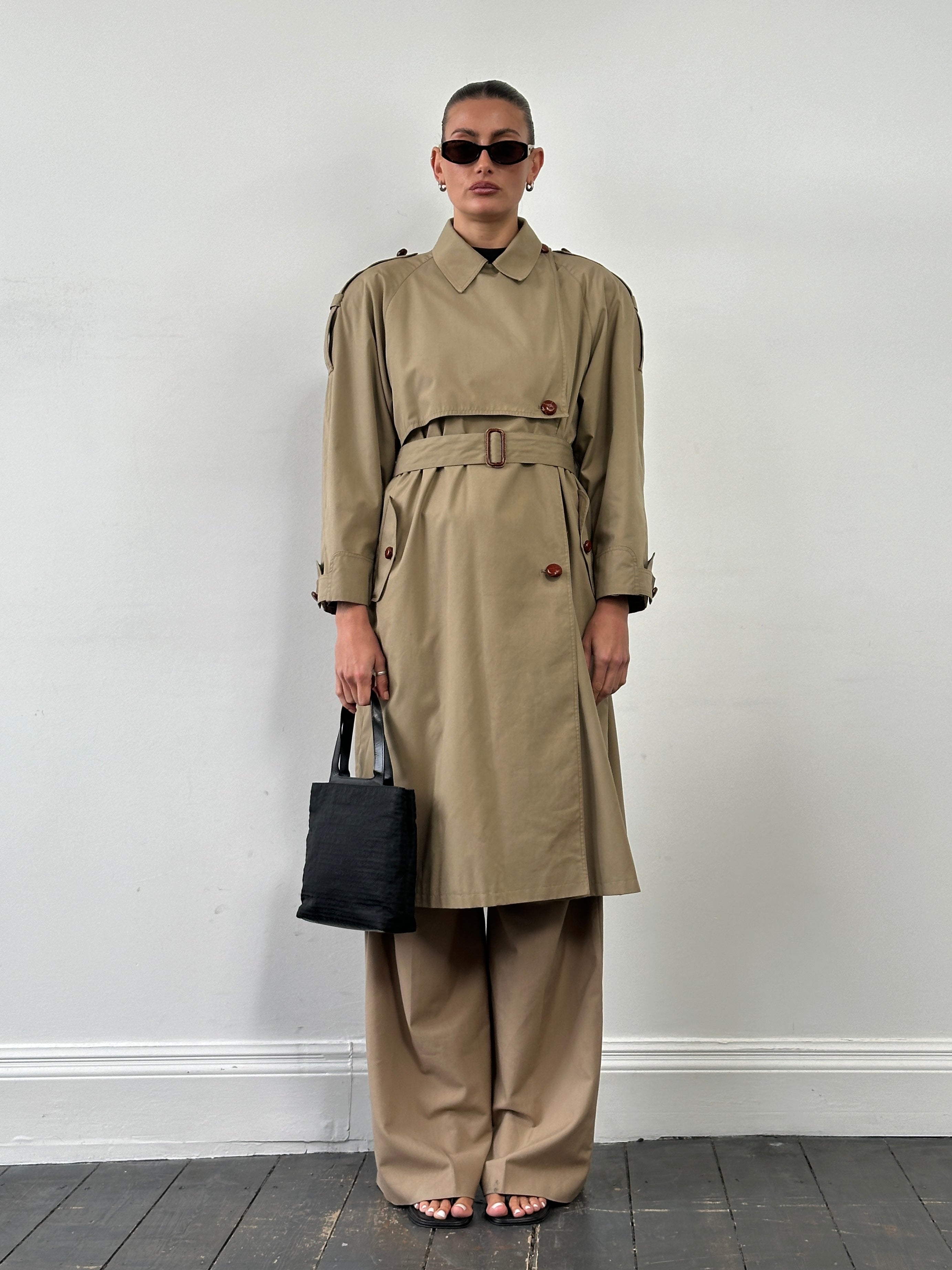 Vintage 1980s Nova Check belted trench coat, mid-length coat with classic pattern, worn by a person in a casual outdoor setting.