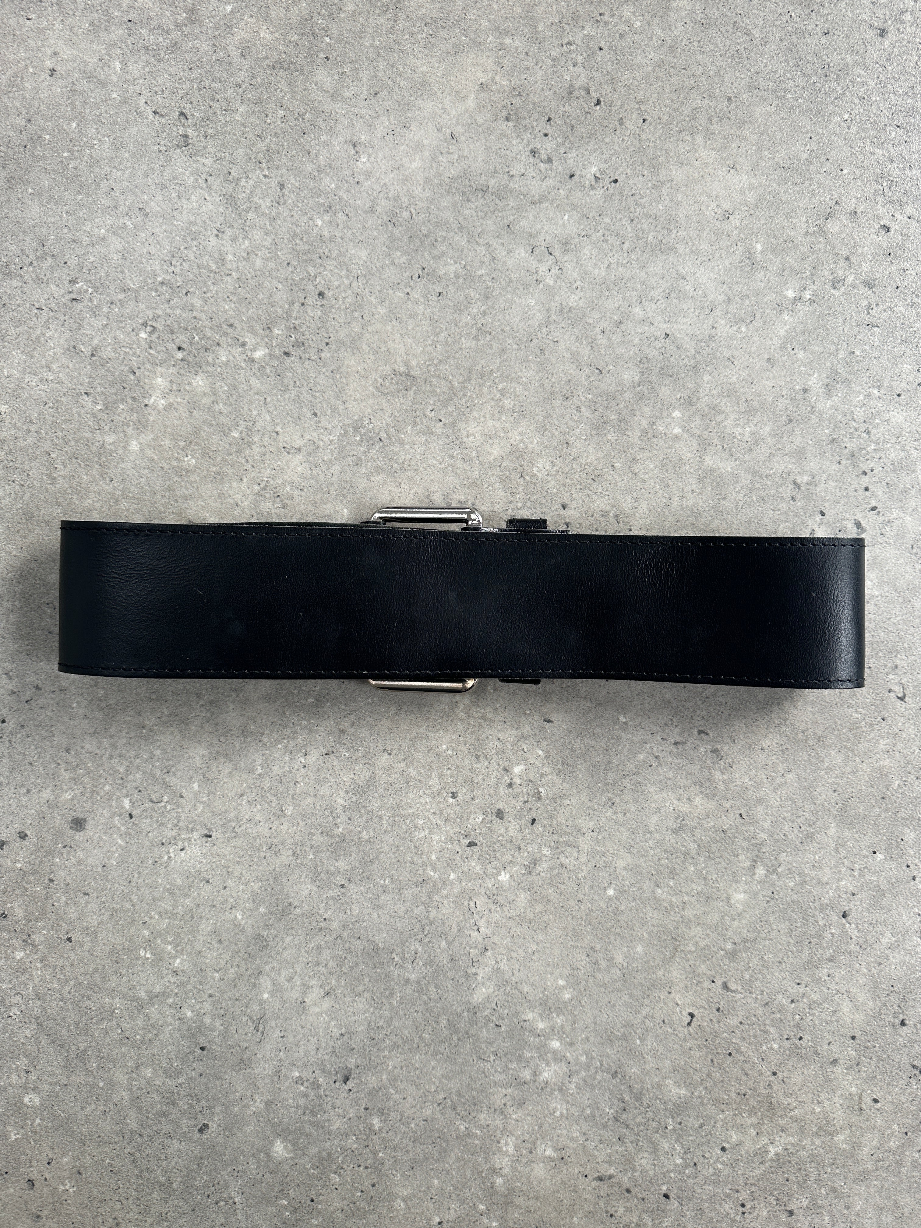 Vintage 2000s chunky leather belt with eyelets, featuring a wide design and adjustable W25-30 size, showcasing a retro style.