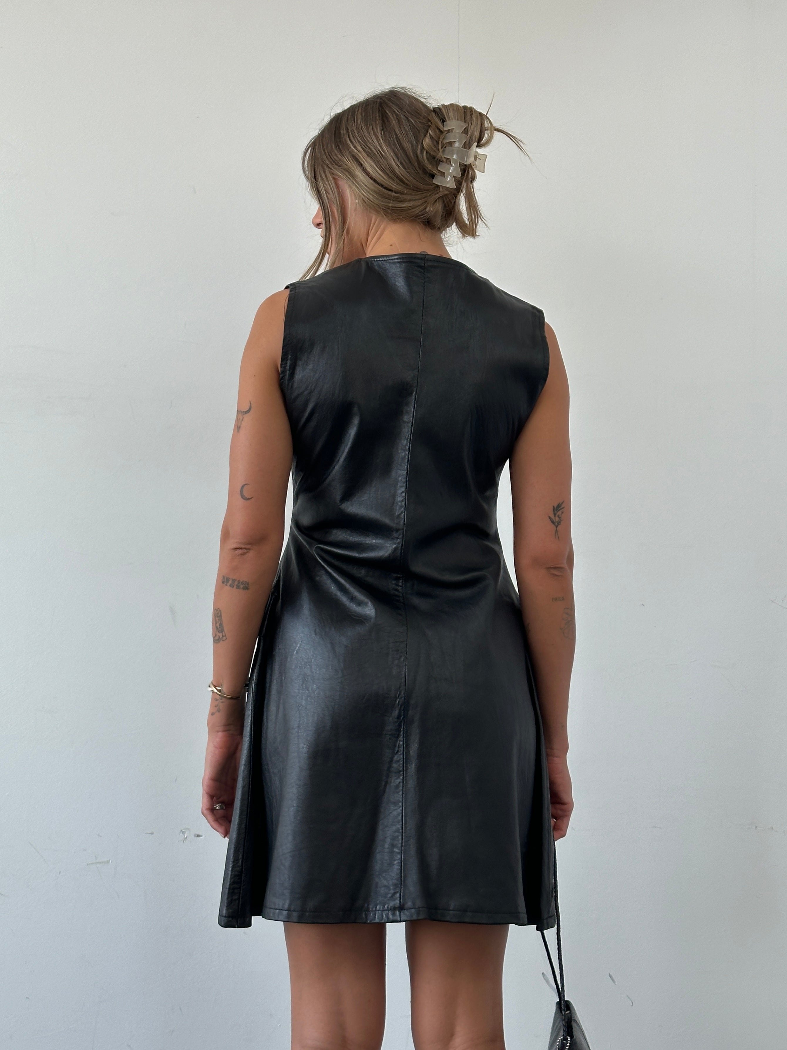 Vintage fitted button-up leather dress in size small, featuring a classic collar and sleek silhouette.