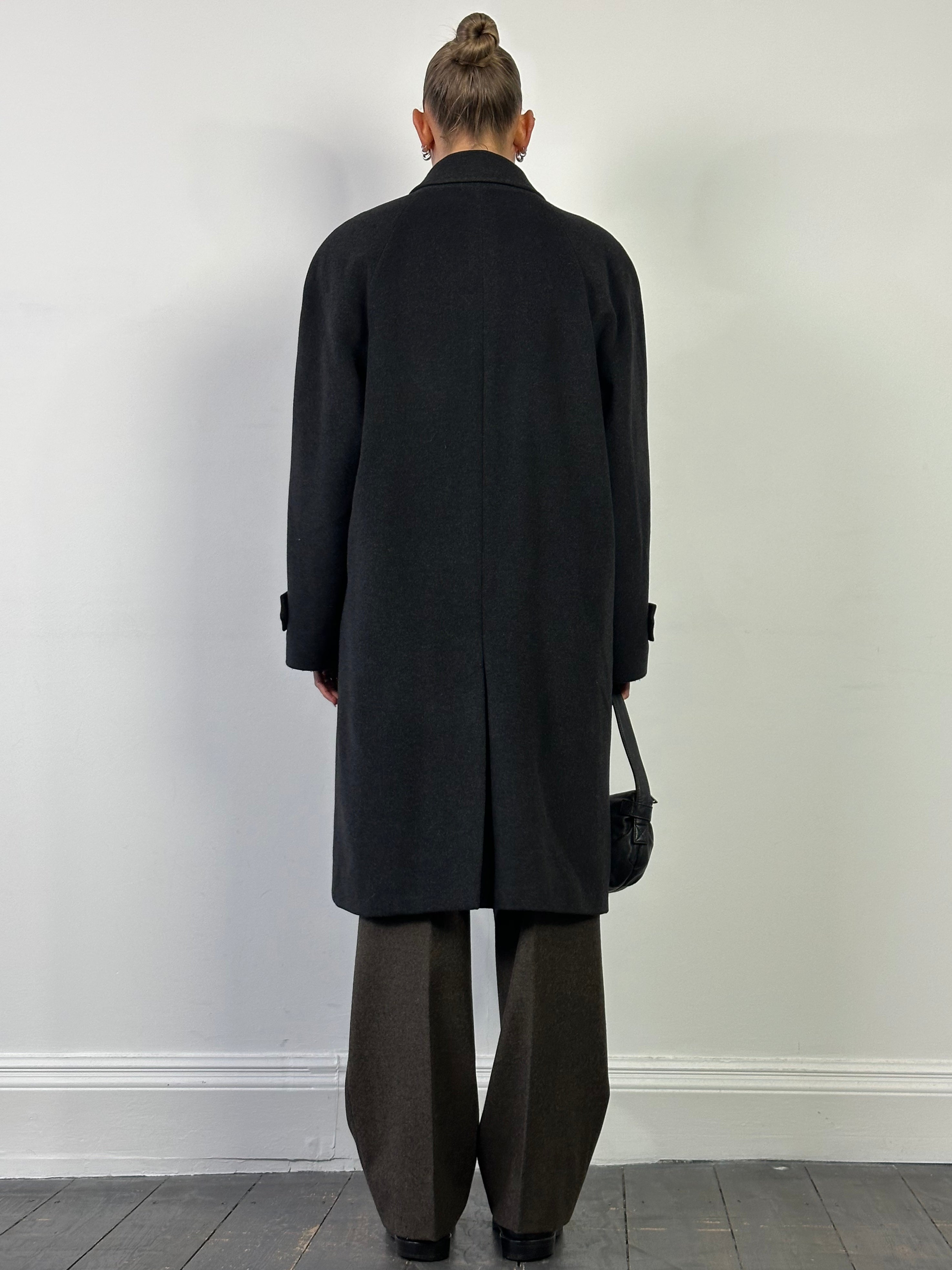 Vintage Italian vintage wool cashmere coat with concealed placket, displayed on a hanger, showcasing its classic design and textured fabric.