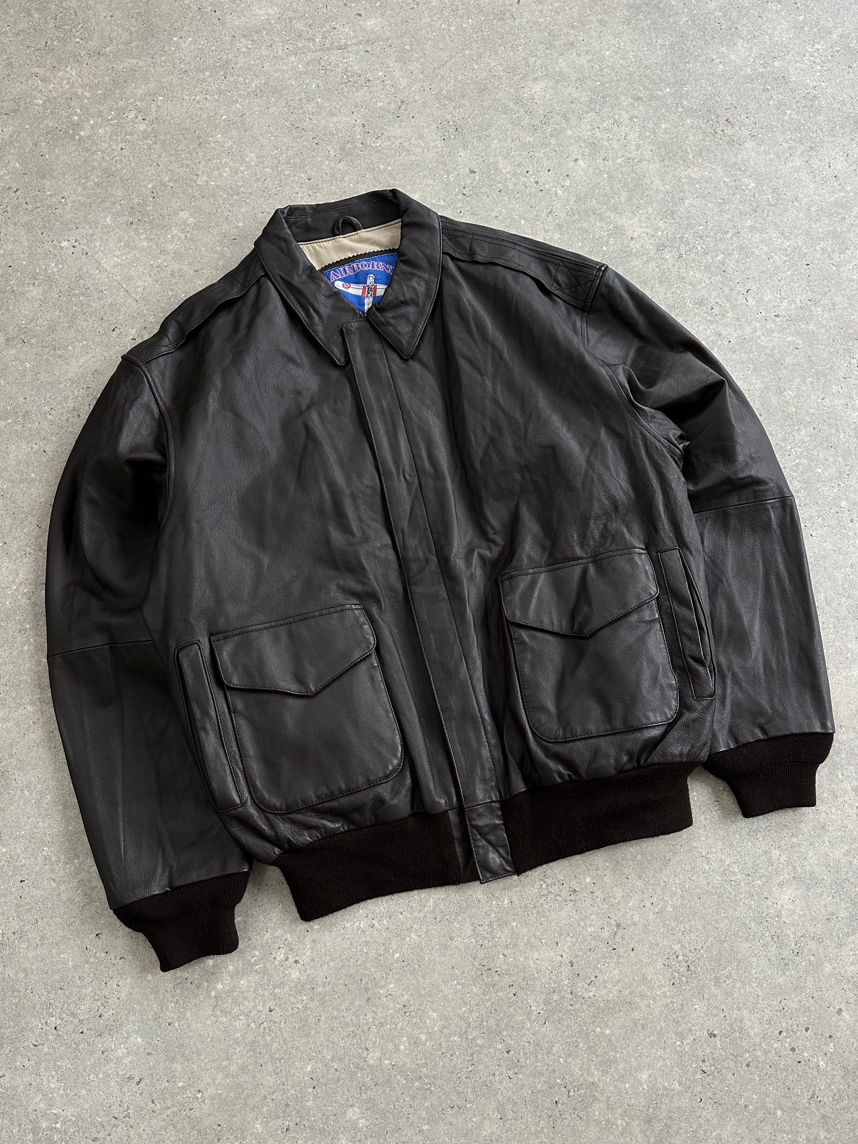 Vintage leather bomber jacket in XL size, featuring classic design, smooth leather texture, and detailed stitching.