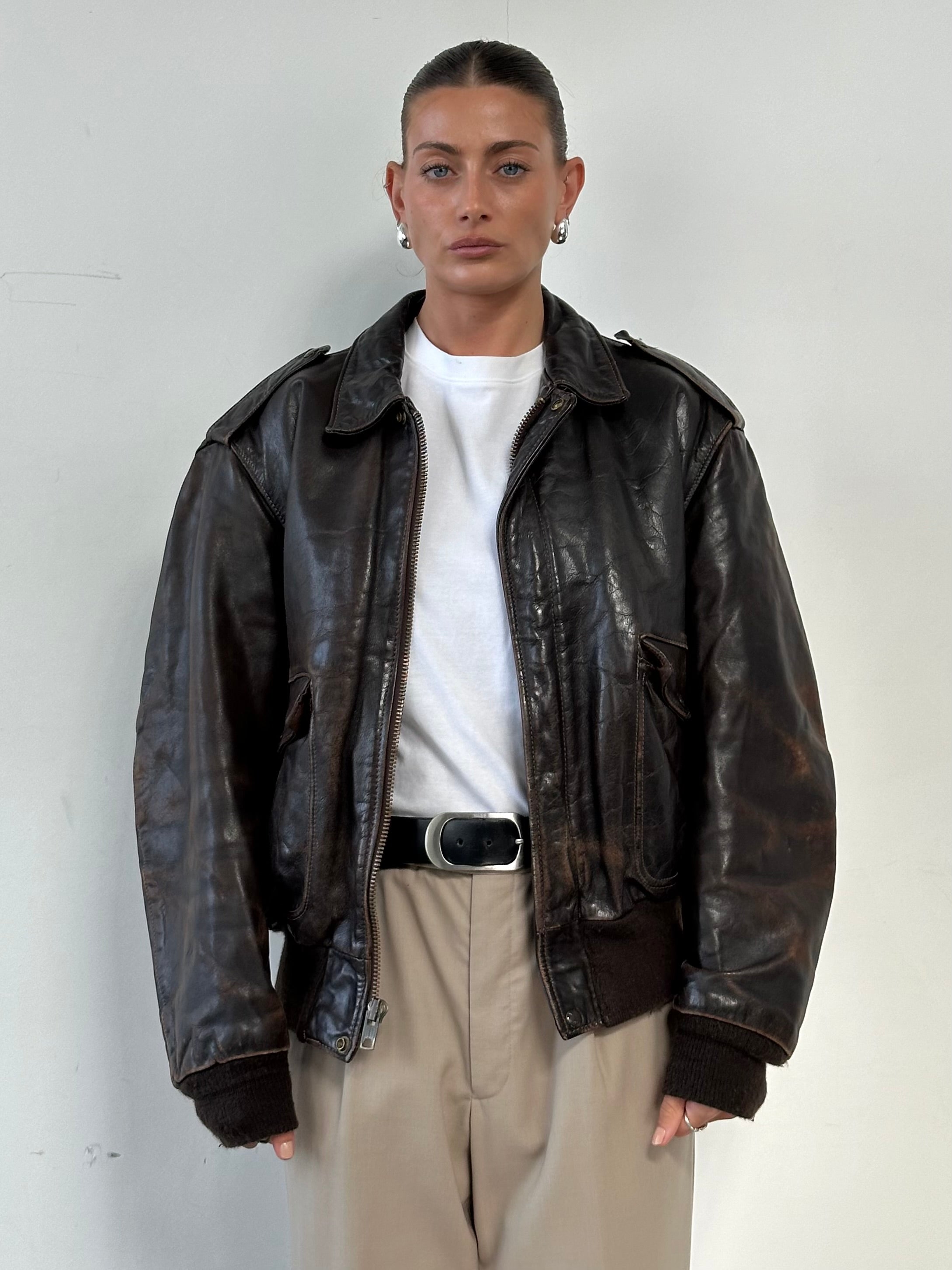 Schott NYC distressed leather bomber jacket in size L/XL, featuring a rugged design and classic fit with visible distressed leather details.