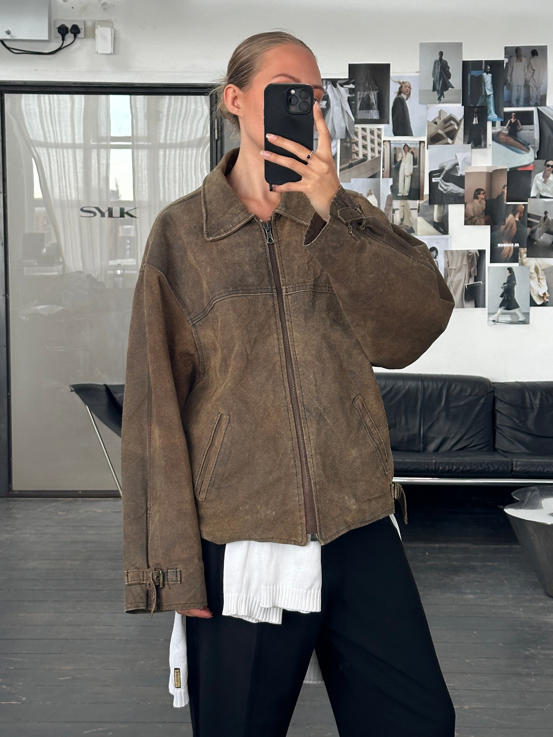 Vintage 1980s boxy leather jacket in XL, featuring classic design and distressed leather, displayed on a hanger.