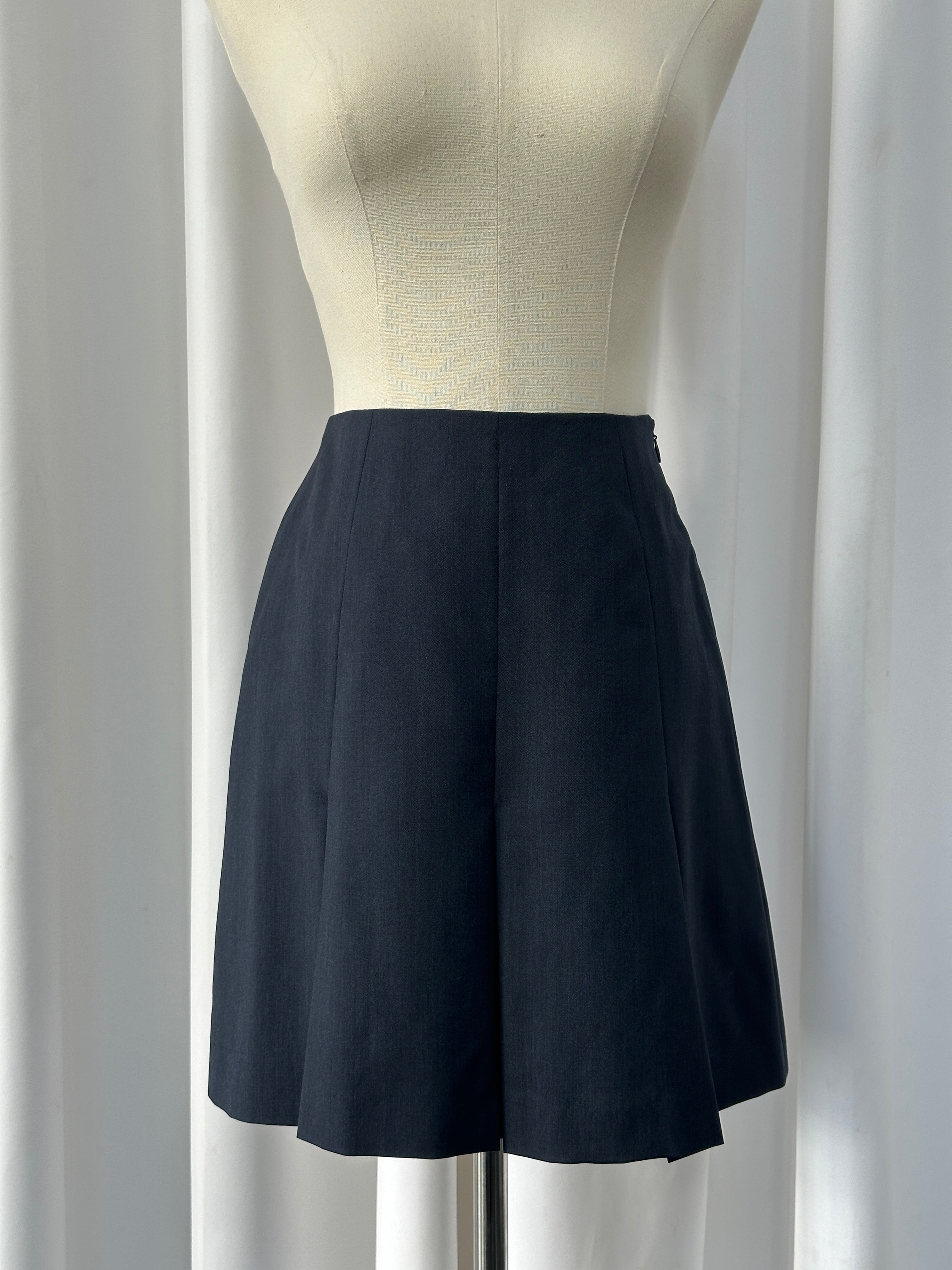 Vintage Italian 1990s pure Merino wool pleated mini skirt in warm earthy tones, showcasing classic mid-thigh length and elegant pleats.