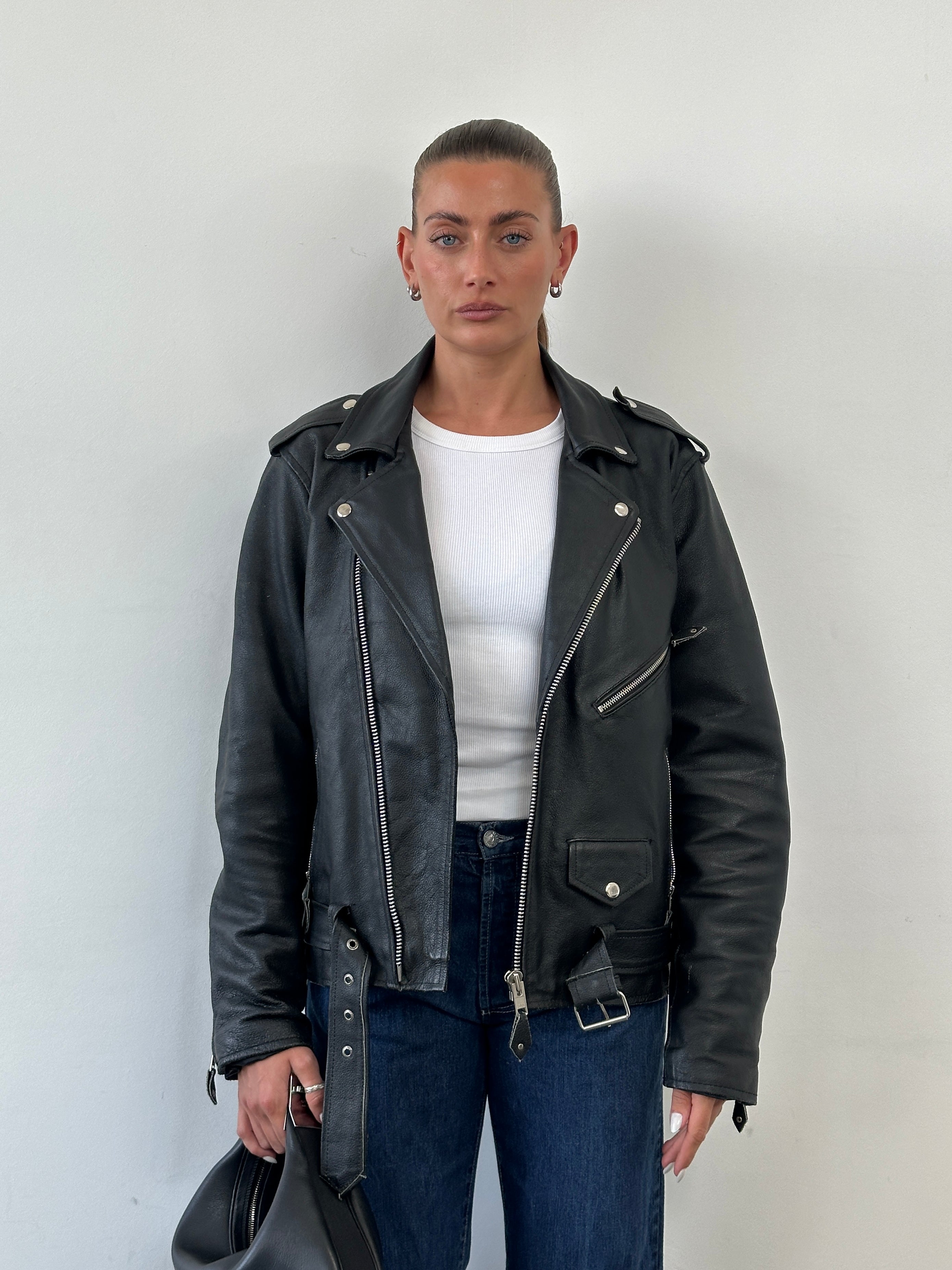 Vintage leather biker jacket in size M/L with classic design, featuring distressed brown leather and metal hardware.
