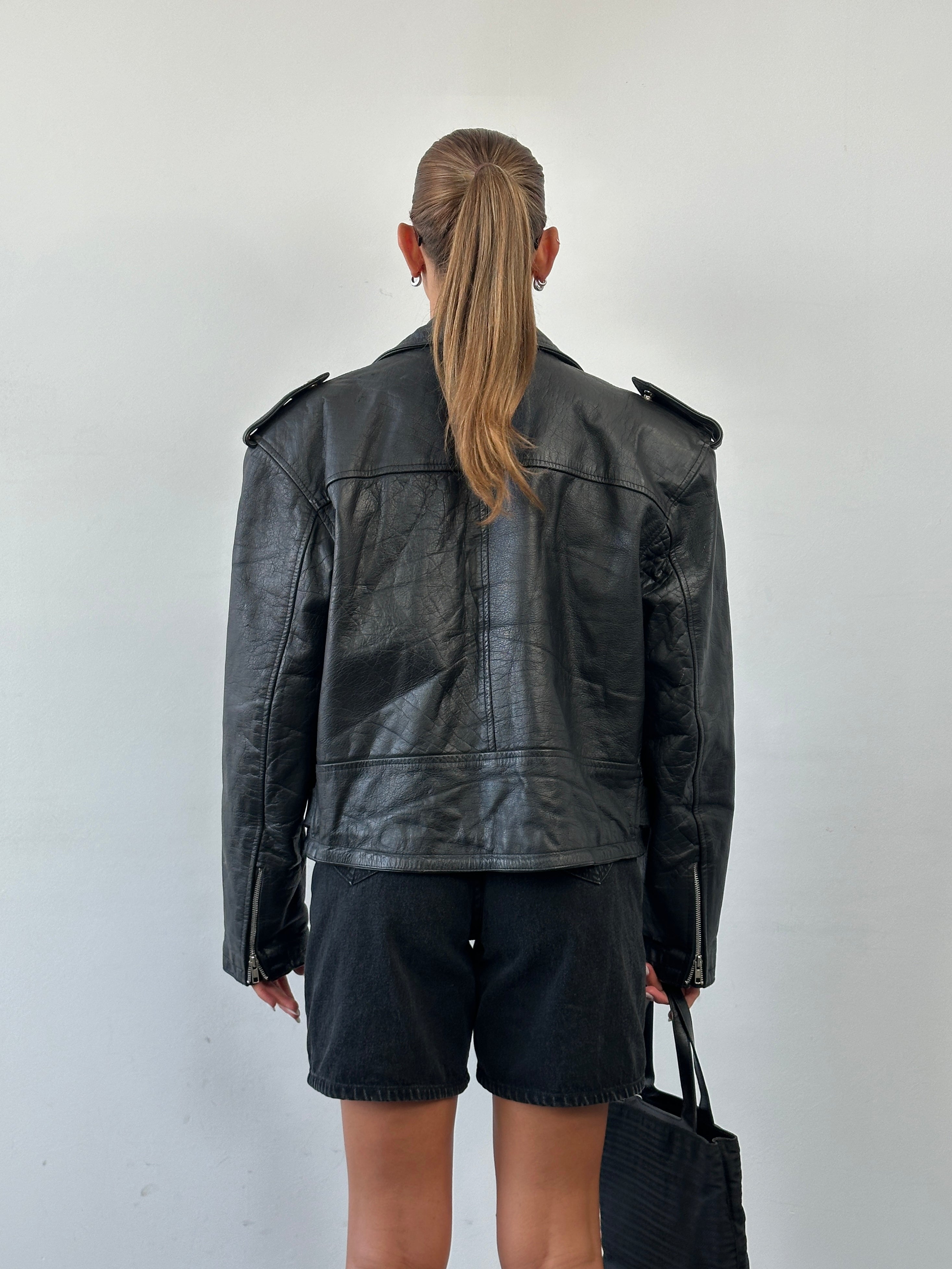 Vintage 1990s leather biker jacket in size large, featuring classic design and rugged leather texture.