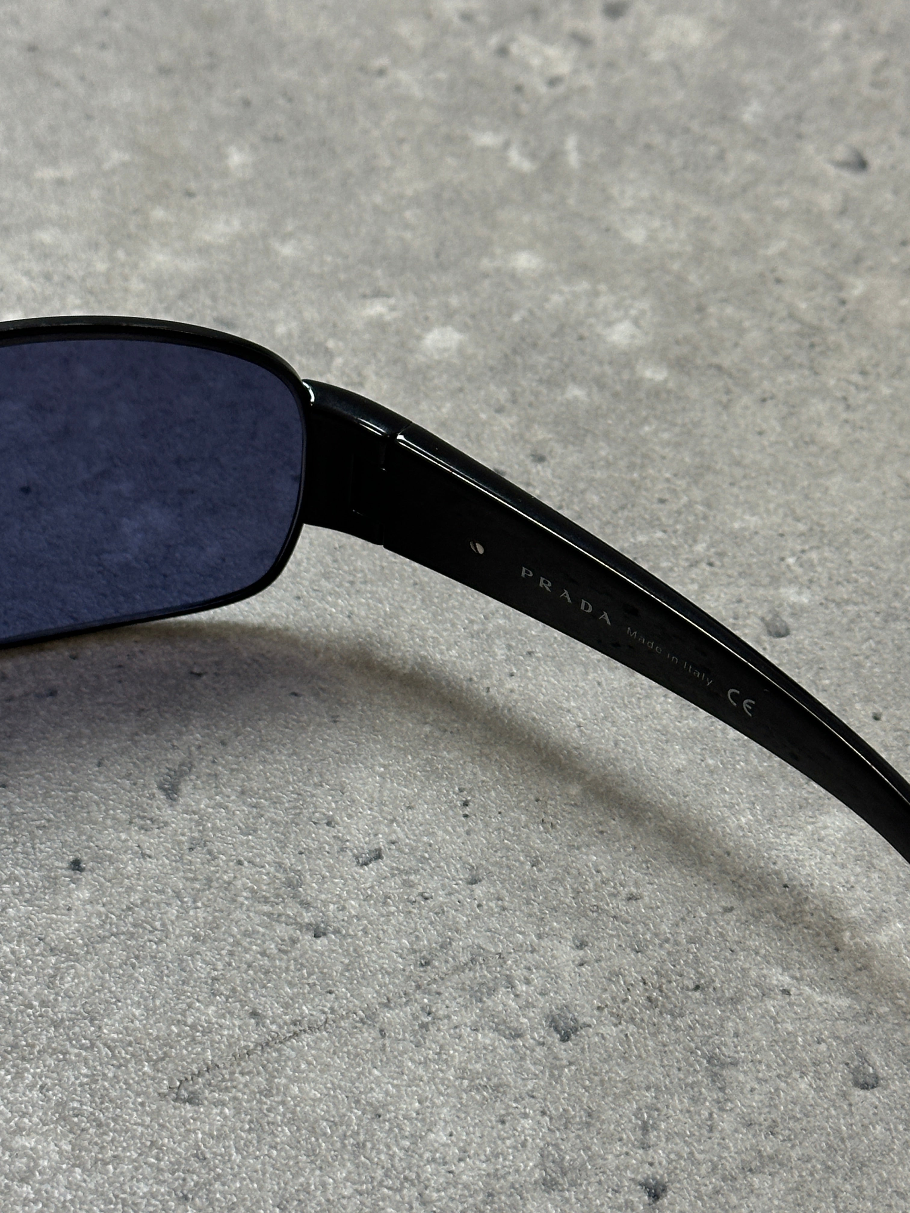 Prada aviator shield sunglasses with dark tinted lenses and metal frame, stylish eyewear for sun protection.