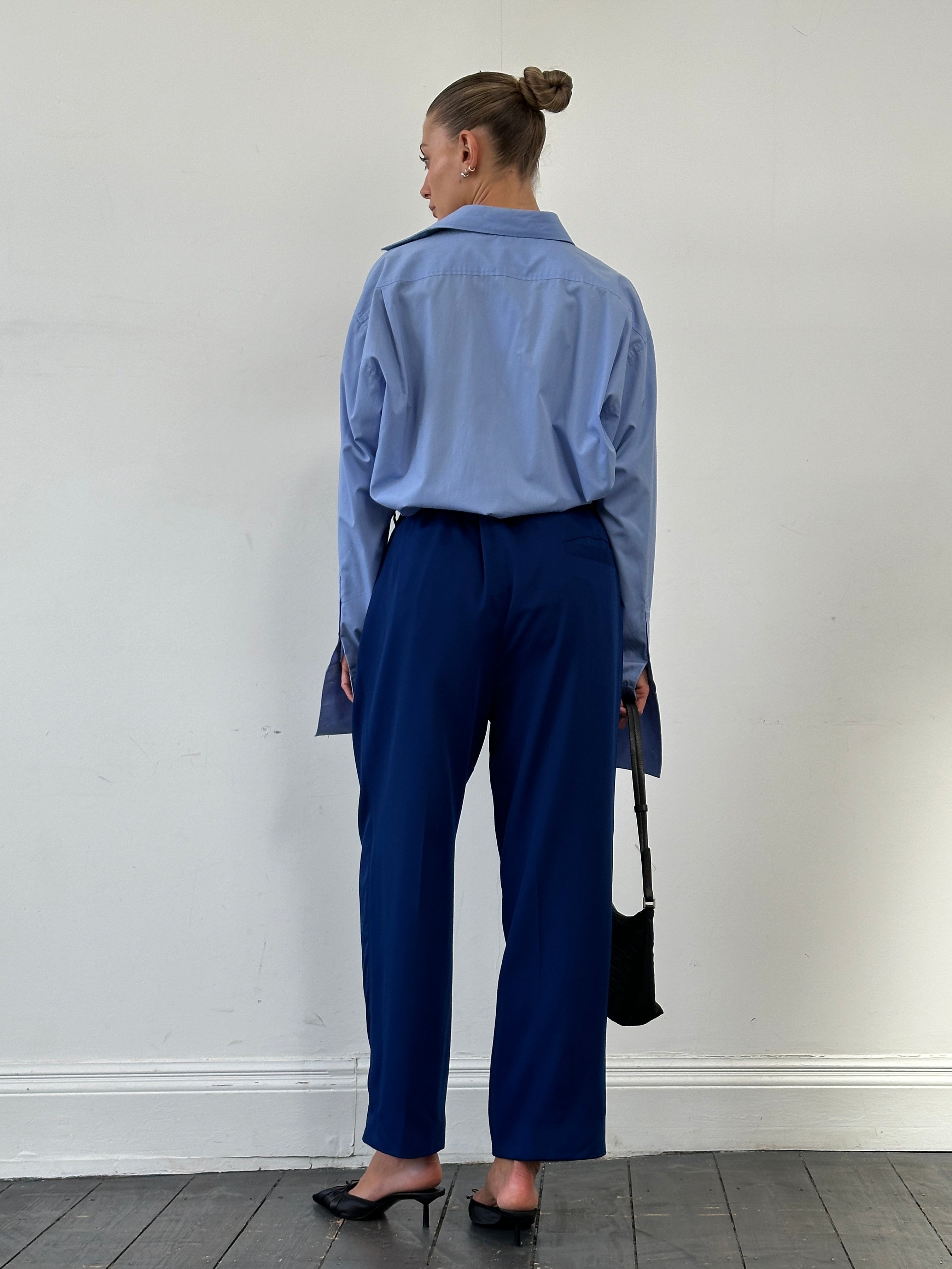 Versace Classic V2 wool pleated high-waisted tailored trousers in dark fabric, featuring a structured fit and waistband detail.