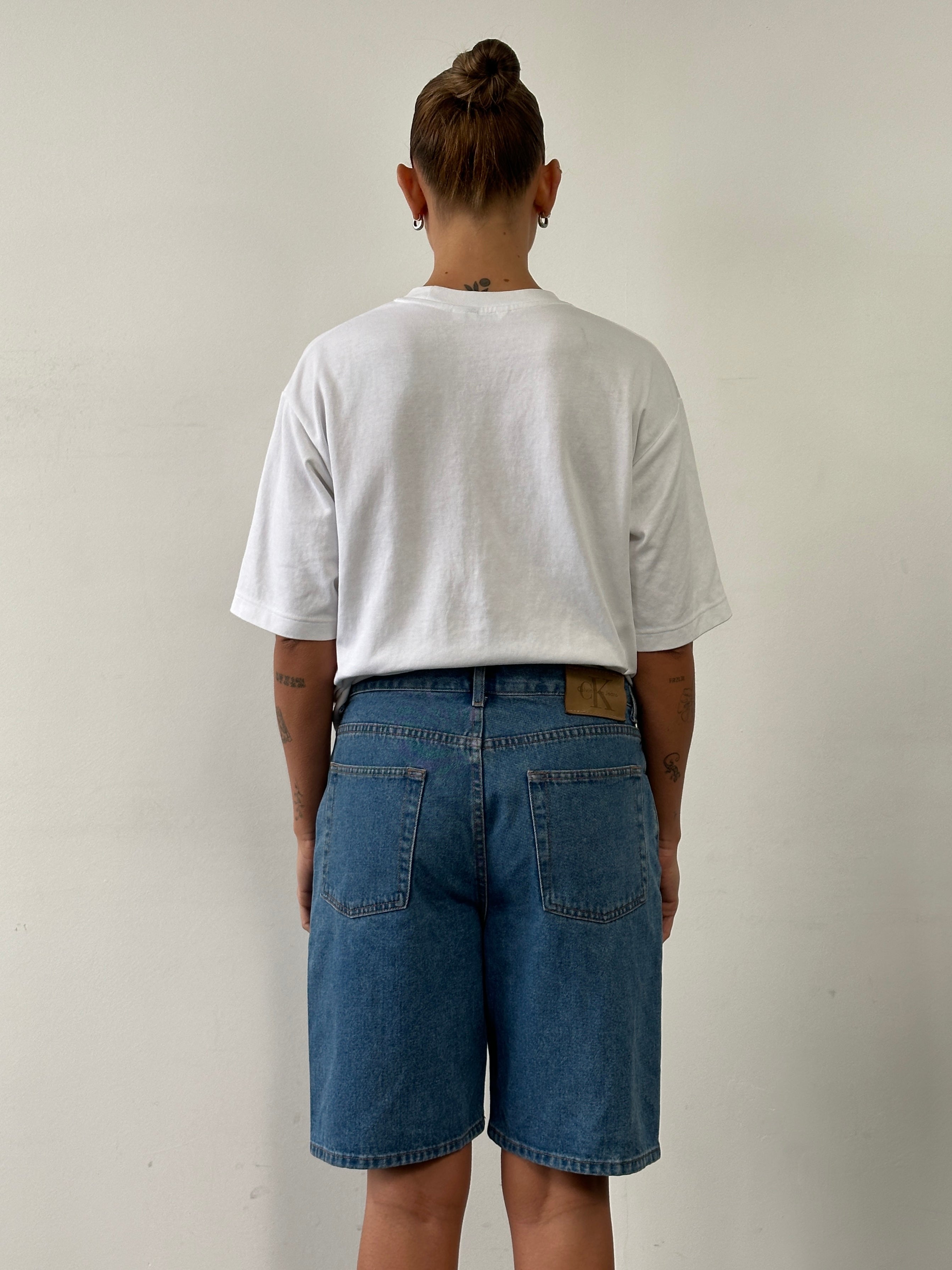 Calvin Klein CK loose leg denim shorts in W32 with distressed details, casual fit, and classic blue wash.