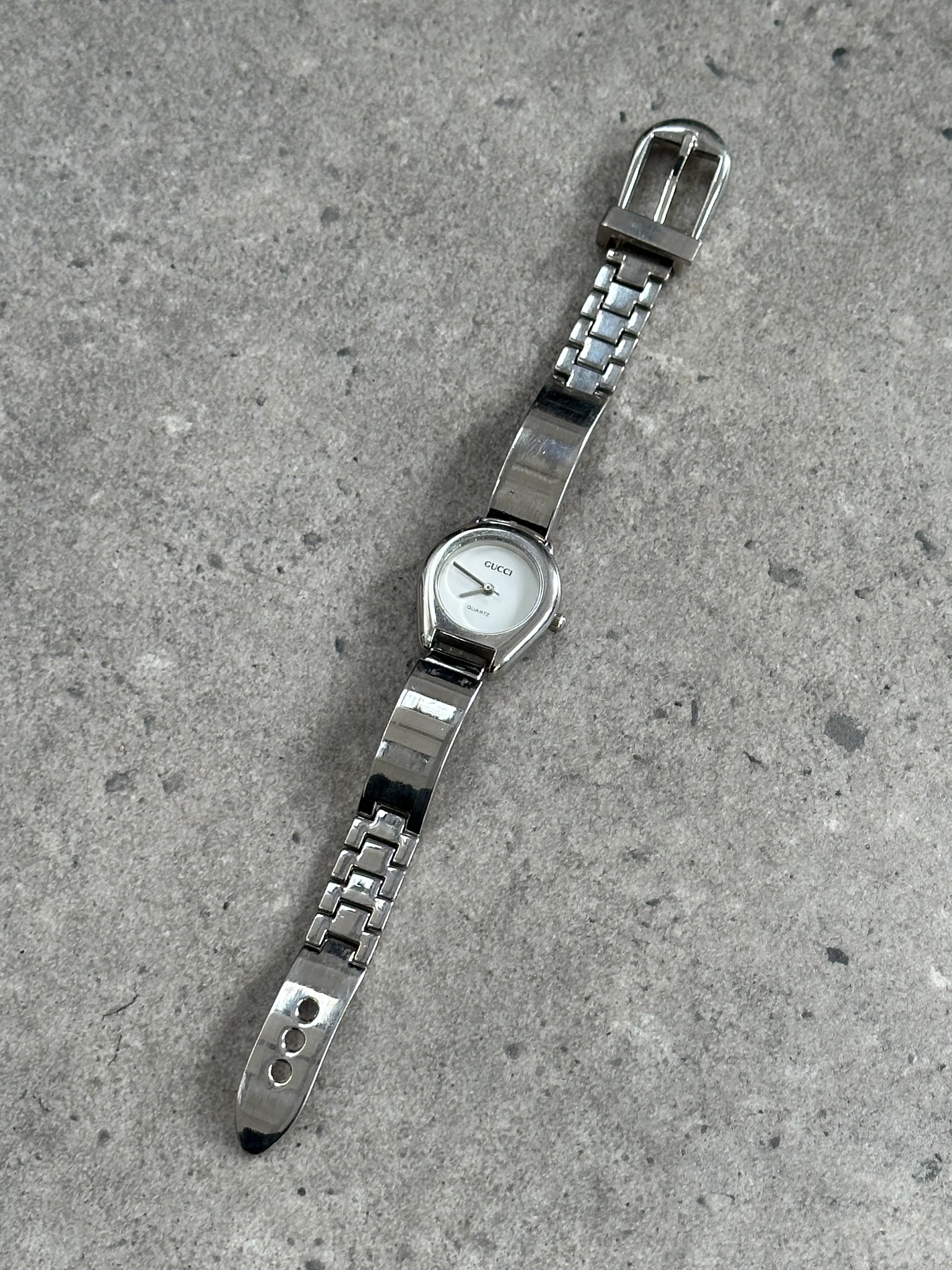 Gucci 1990s stainless steel quartz watch with sleek design, visible watch face, and vintage-inspired style.