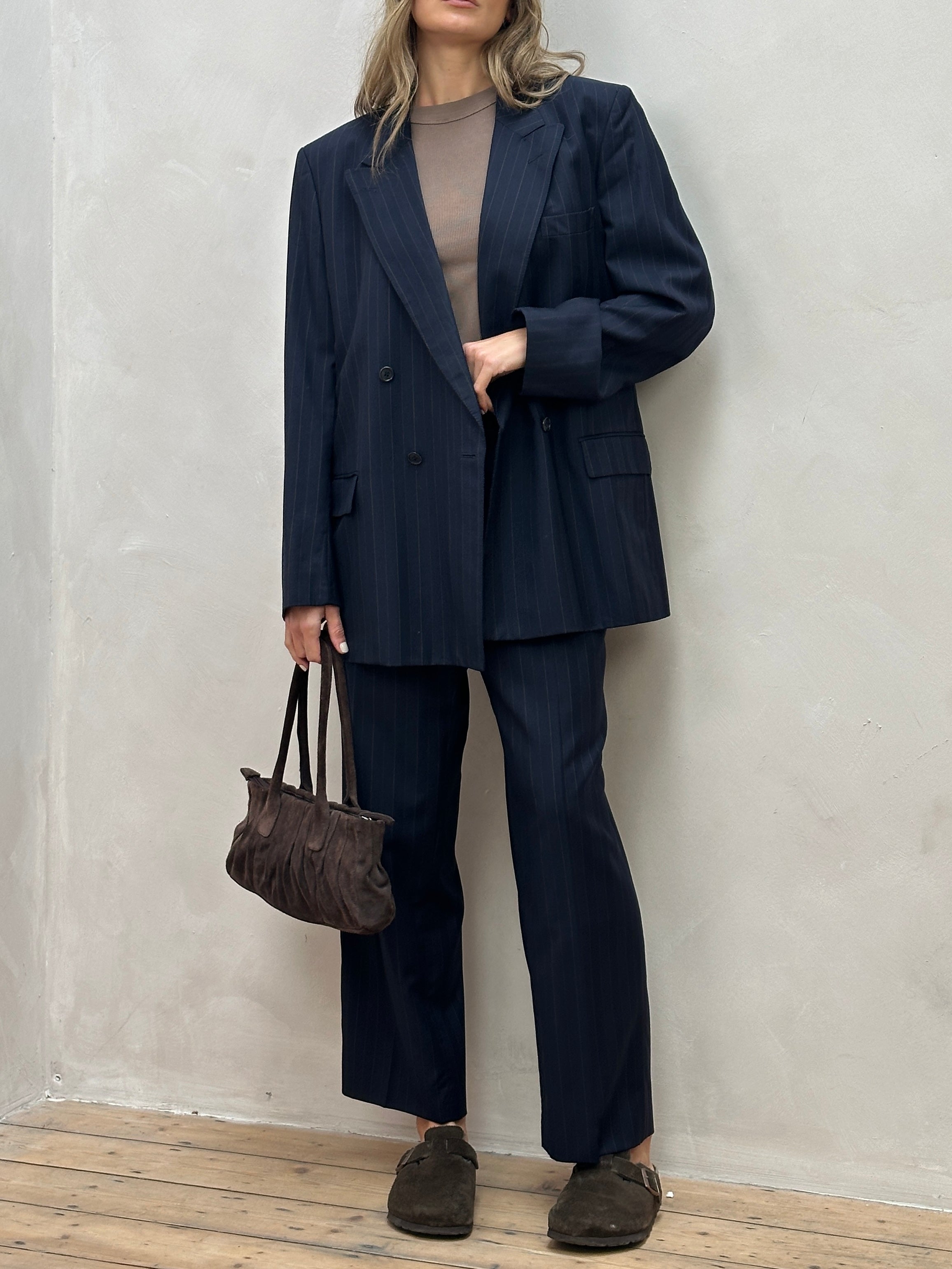 Christian Dior pinstripe wool jumpsuit with double-breasted design, tailored fit, in size 44R/W34, featuring classic suit details.