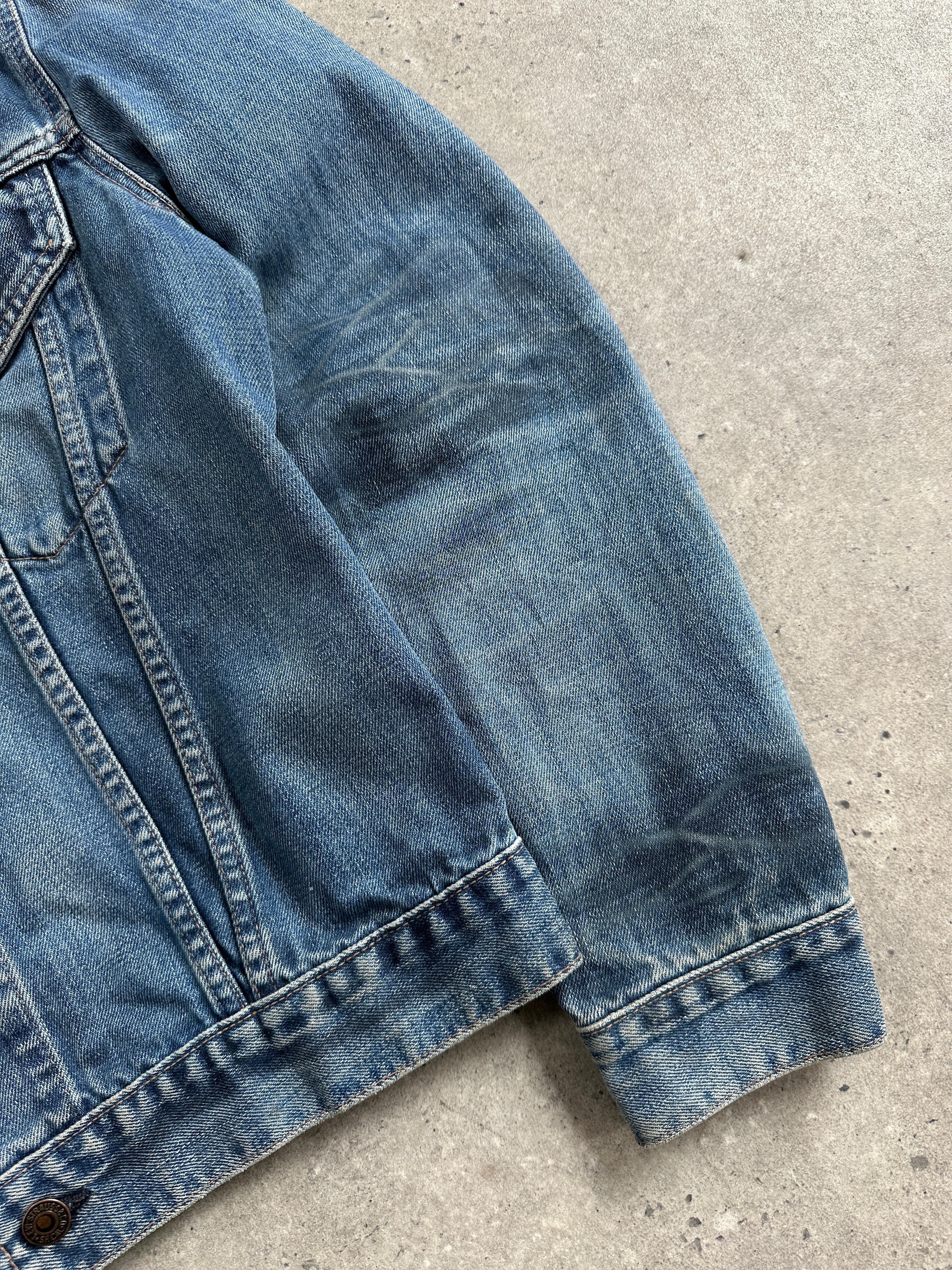Levi’s 1990s faded denim jacket, size M, showing classic distressed blue denim with a button-front and collar detail.