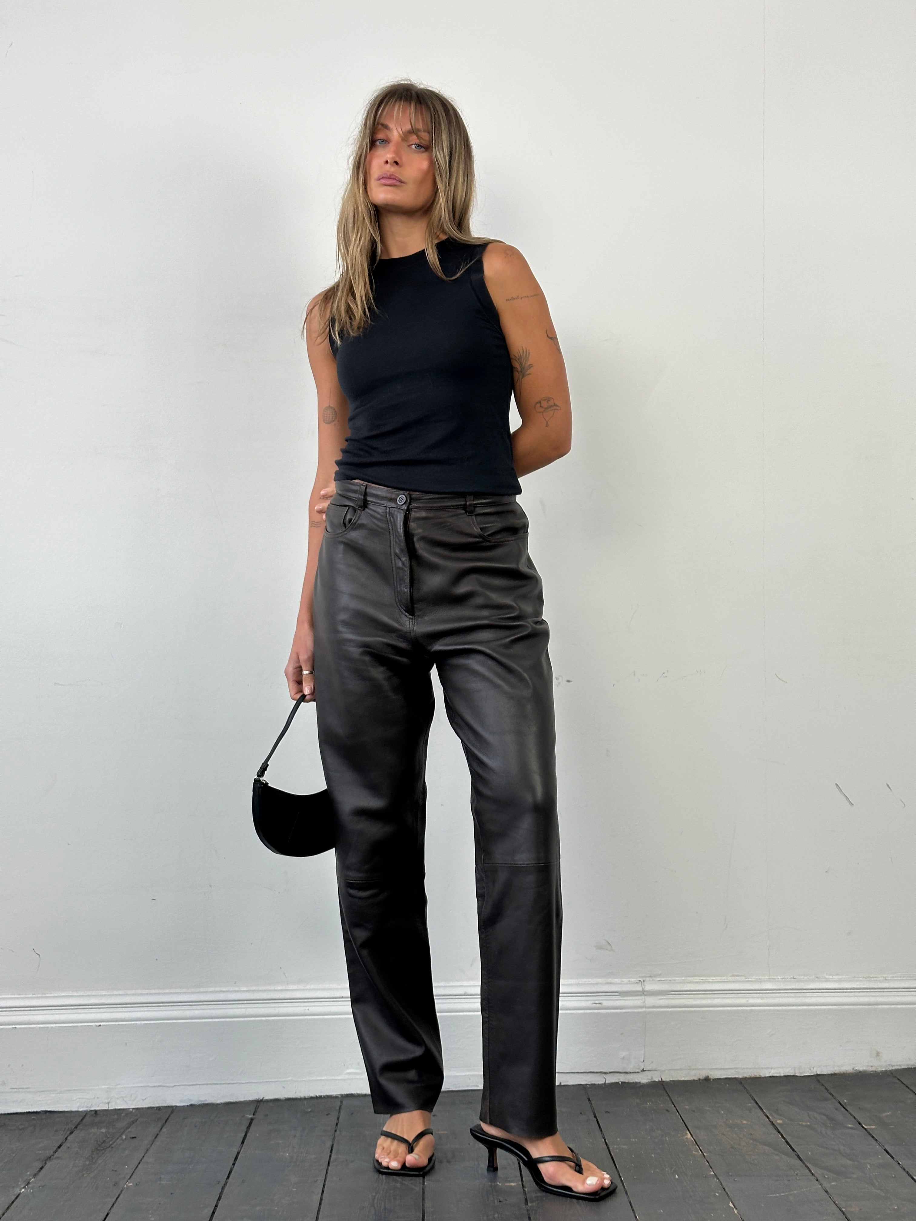 Jaeger 90s straight leg leather trousers in size W30, shown on a model, featuring a sleek fit and classic black leather material.
