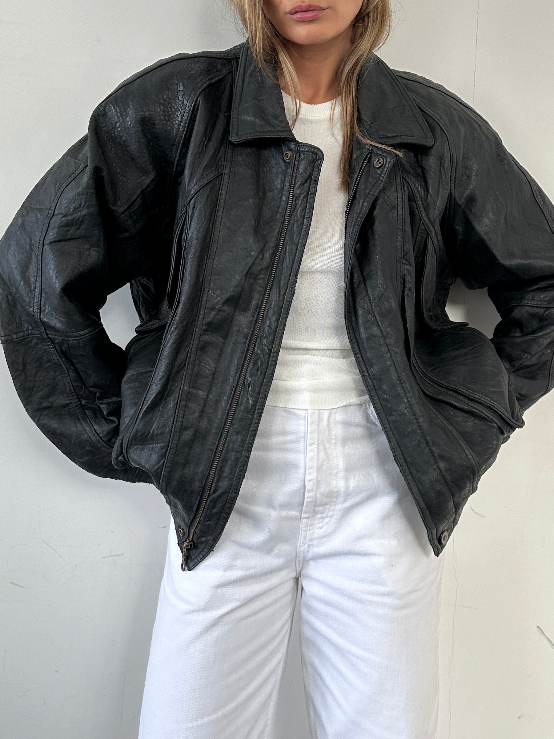 Vintage distressed leather bomber jacket in size large, featuring rugged texture and classic style, shown on a hanger.