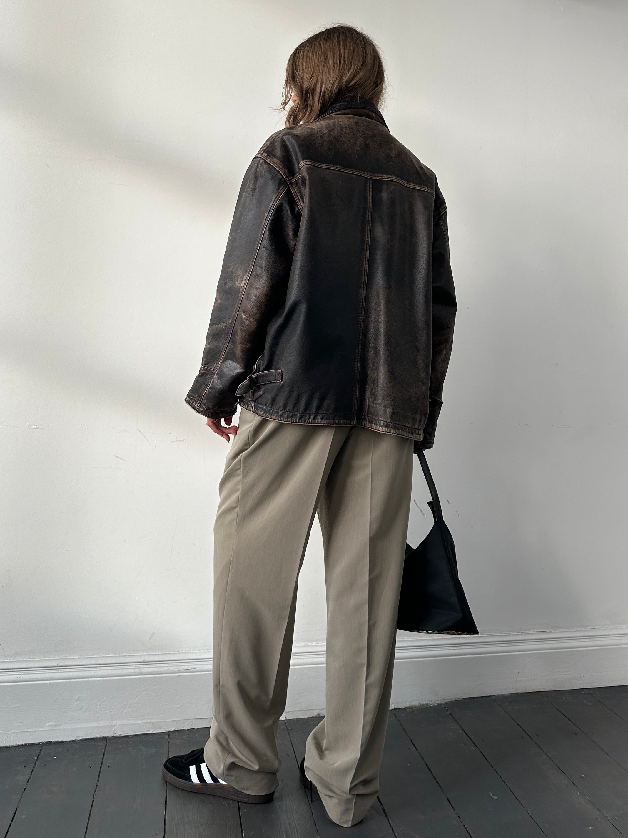 Vintage brand distressed leather jacket in size M/L with a rugged, worn-in look and classic biker style.