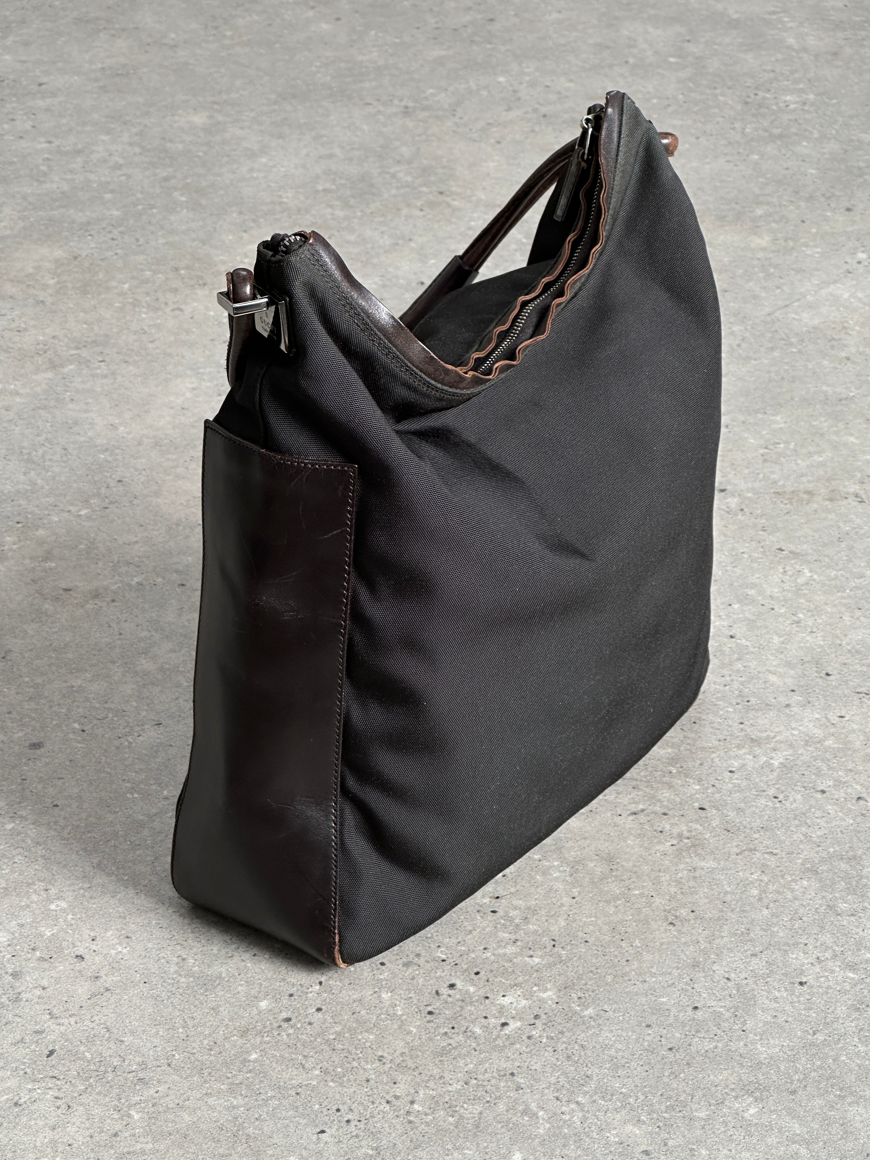 Gucci canvas and leather shoulder bag with adjustable strap, featuring the iconic Gucci monogram pattern and sleek design.