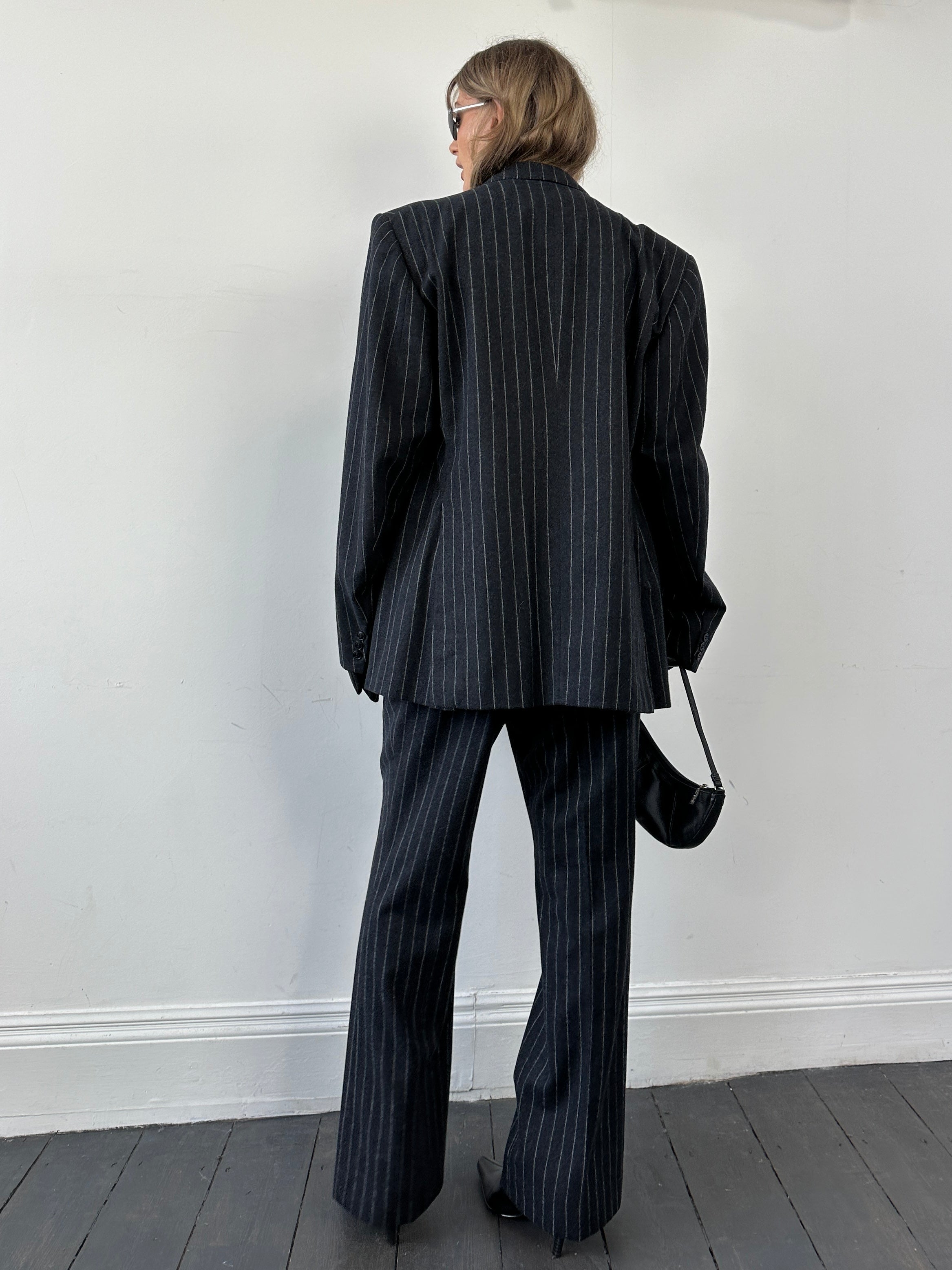 Christian Dior wool double-breasted pinstripe jumpsuit with tailored fit and wide lapels, displayed on a mannequin.