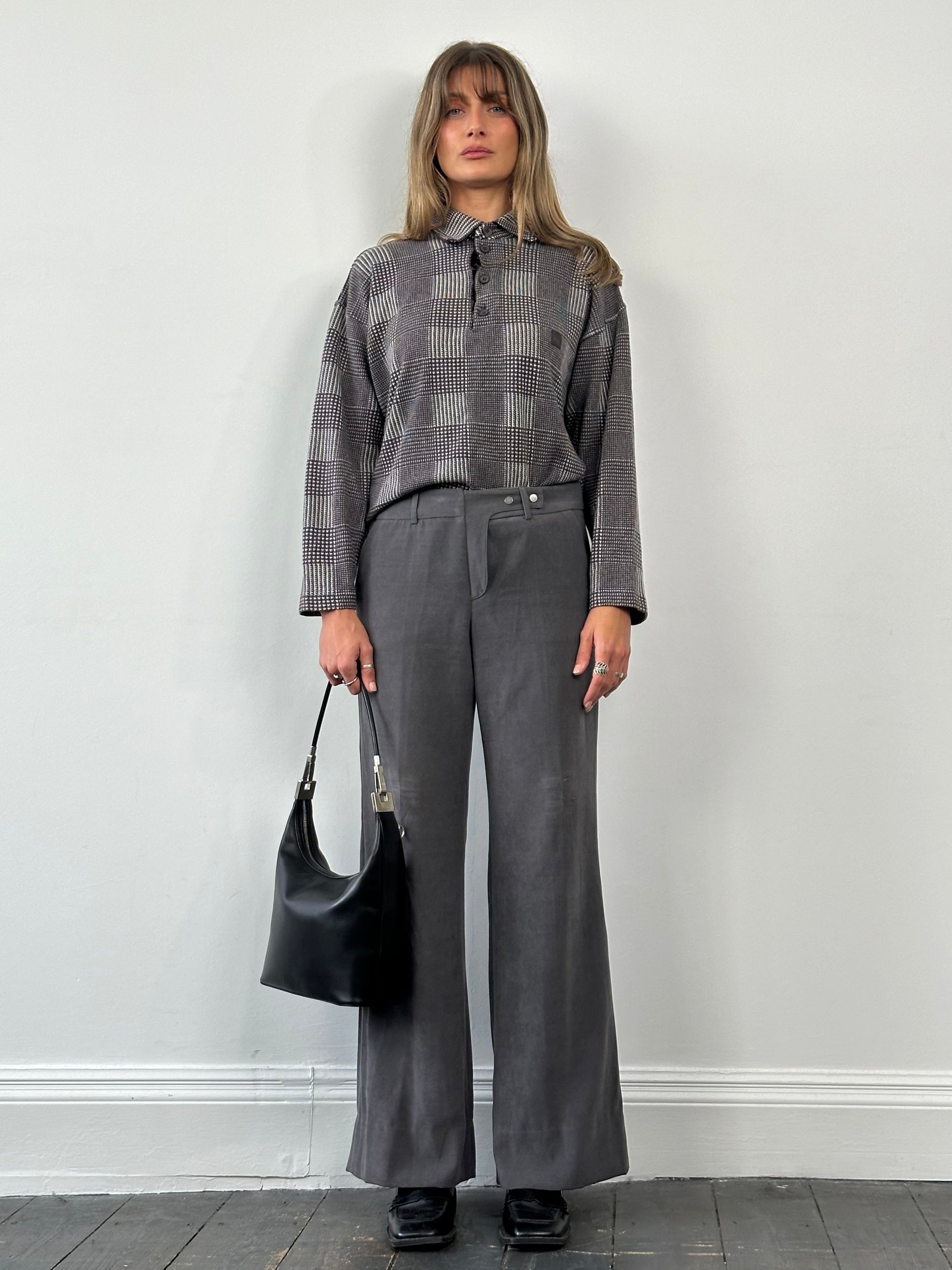 Emporio Armani wide leg low rise trousers in dark fabric, showing front view with waistband and relaxed fit.