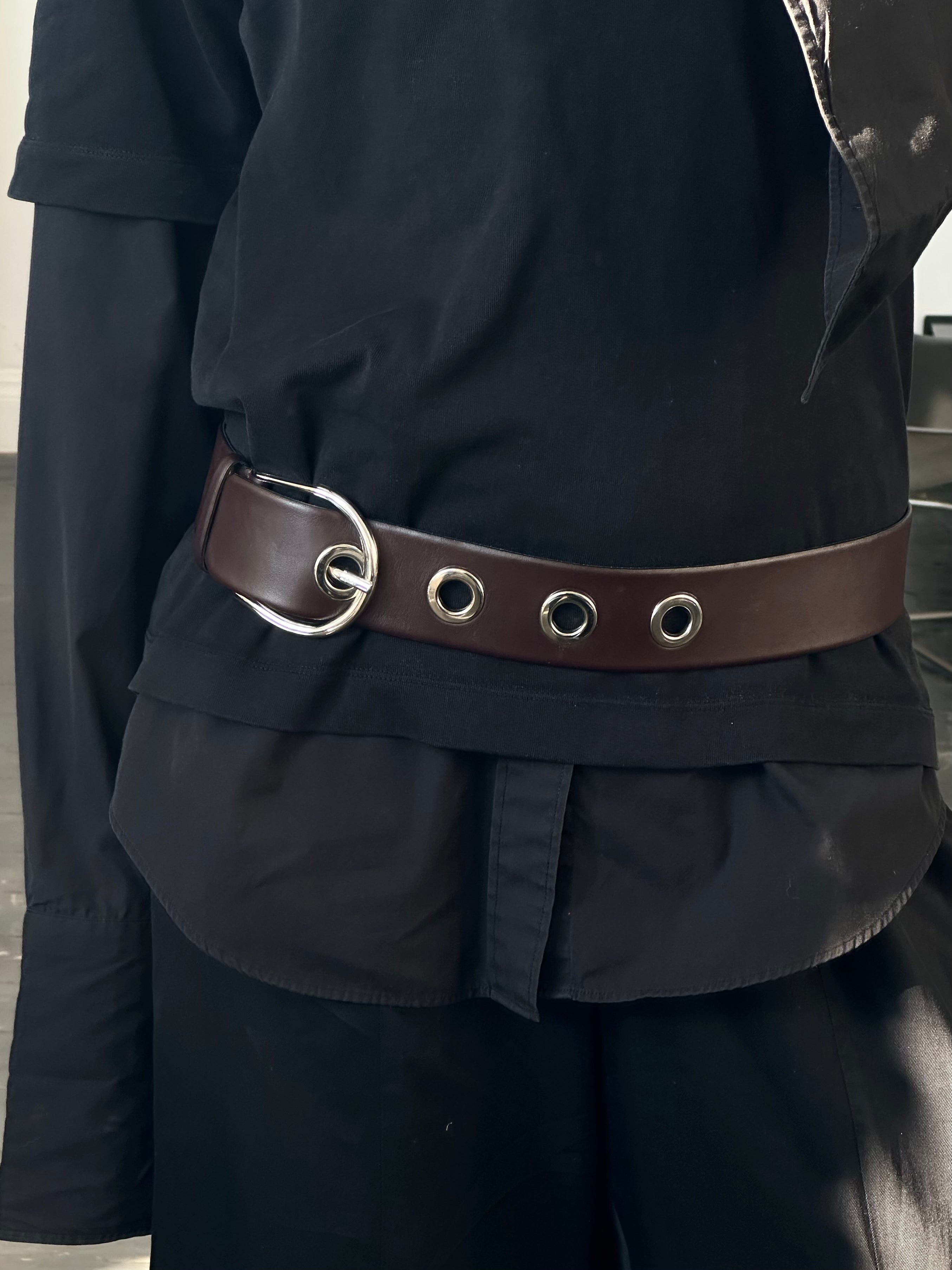 Vintage 1990s eyelet leather belt with adjustable W28-34, featuring metal eyelet details and classic distressed leather finish.