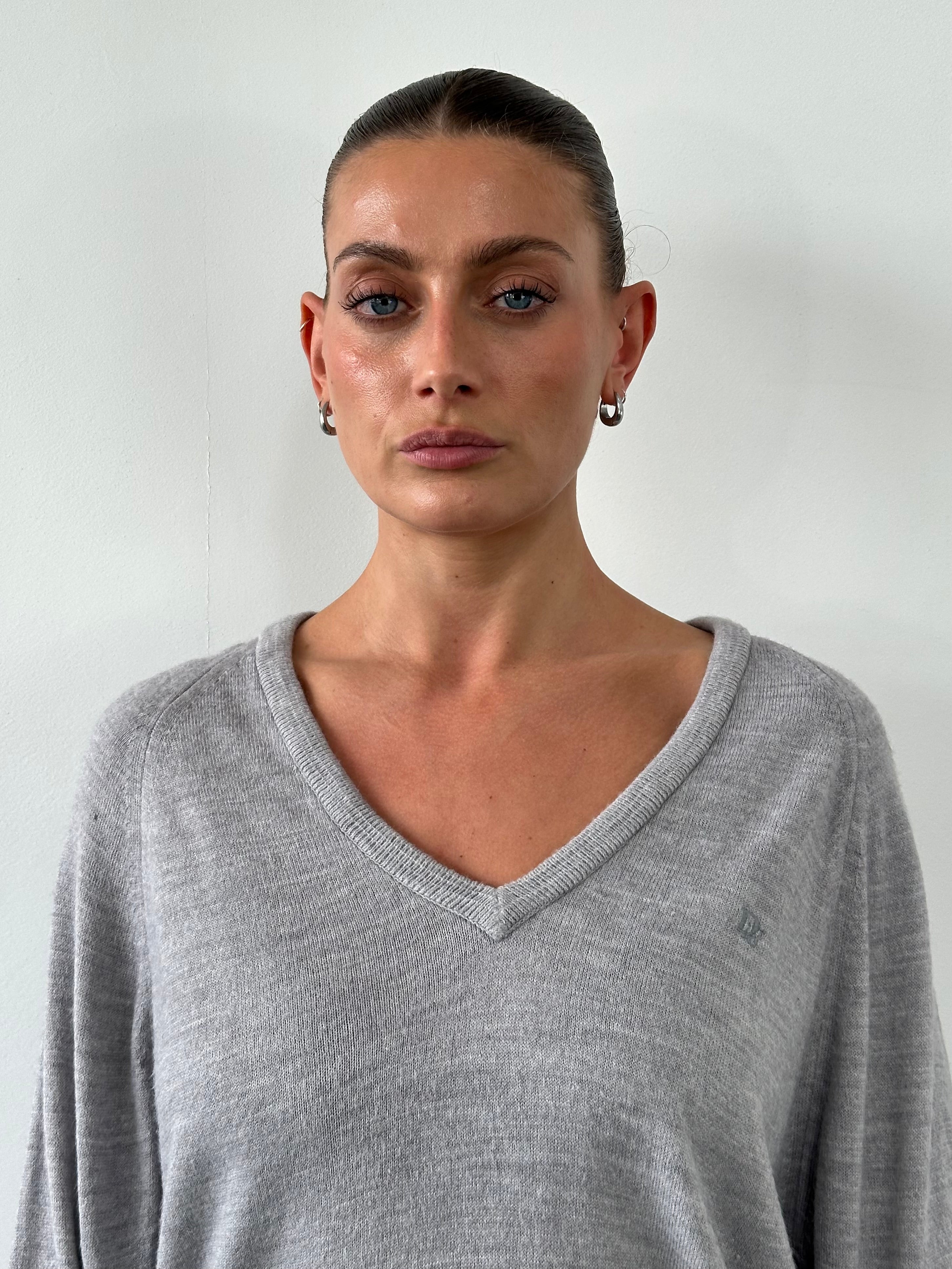 Christian Dior 1980s V-neck logo knitted jumper in black, showing the classic Dior logo pattern and ribbed collar.