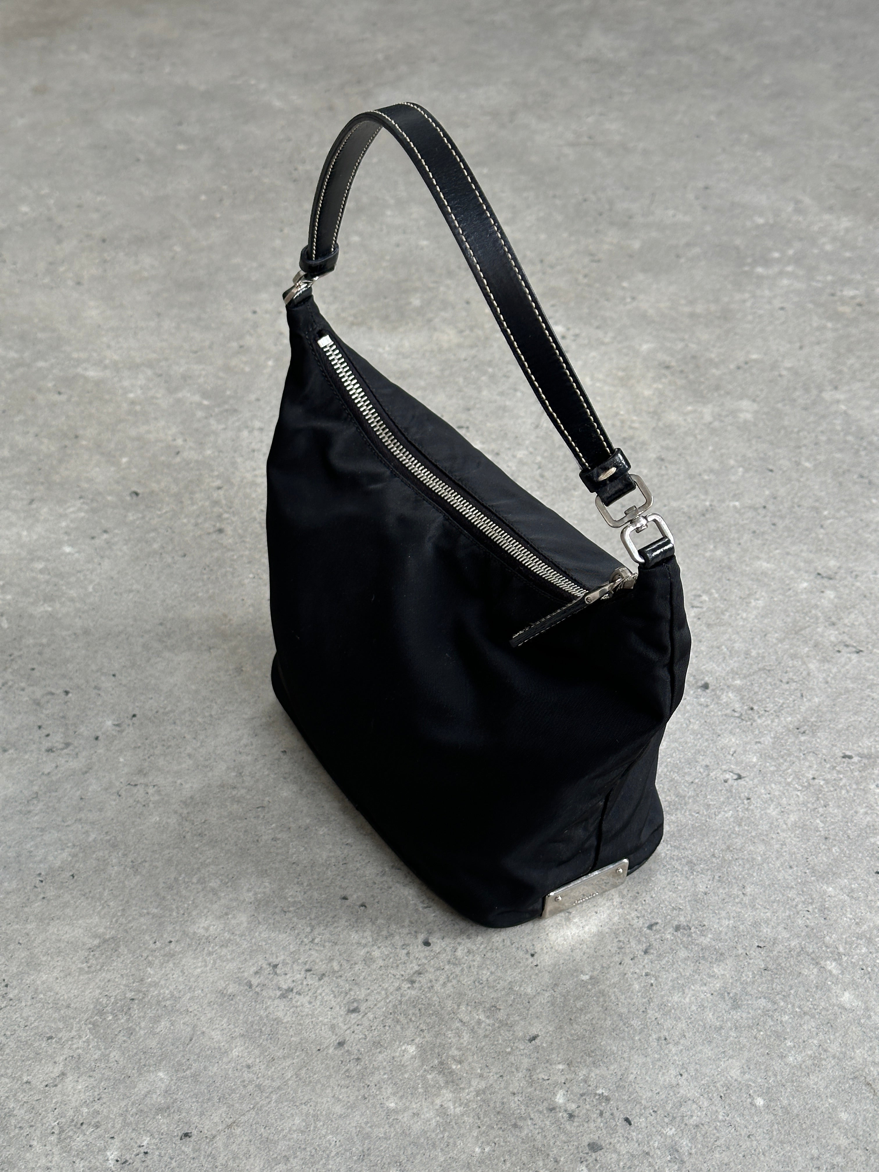 Prada nylon shoulder bag with chrome logo hardware, featuring a sleek design and adjustable strap for versatile styling.