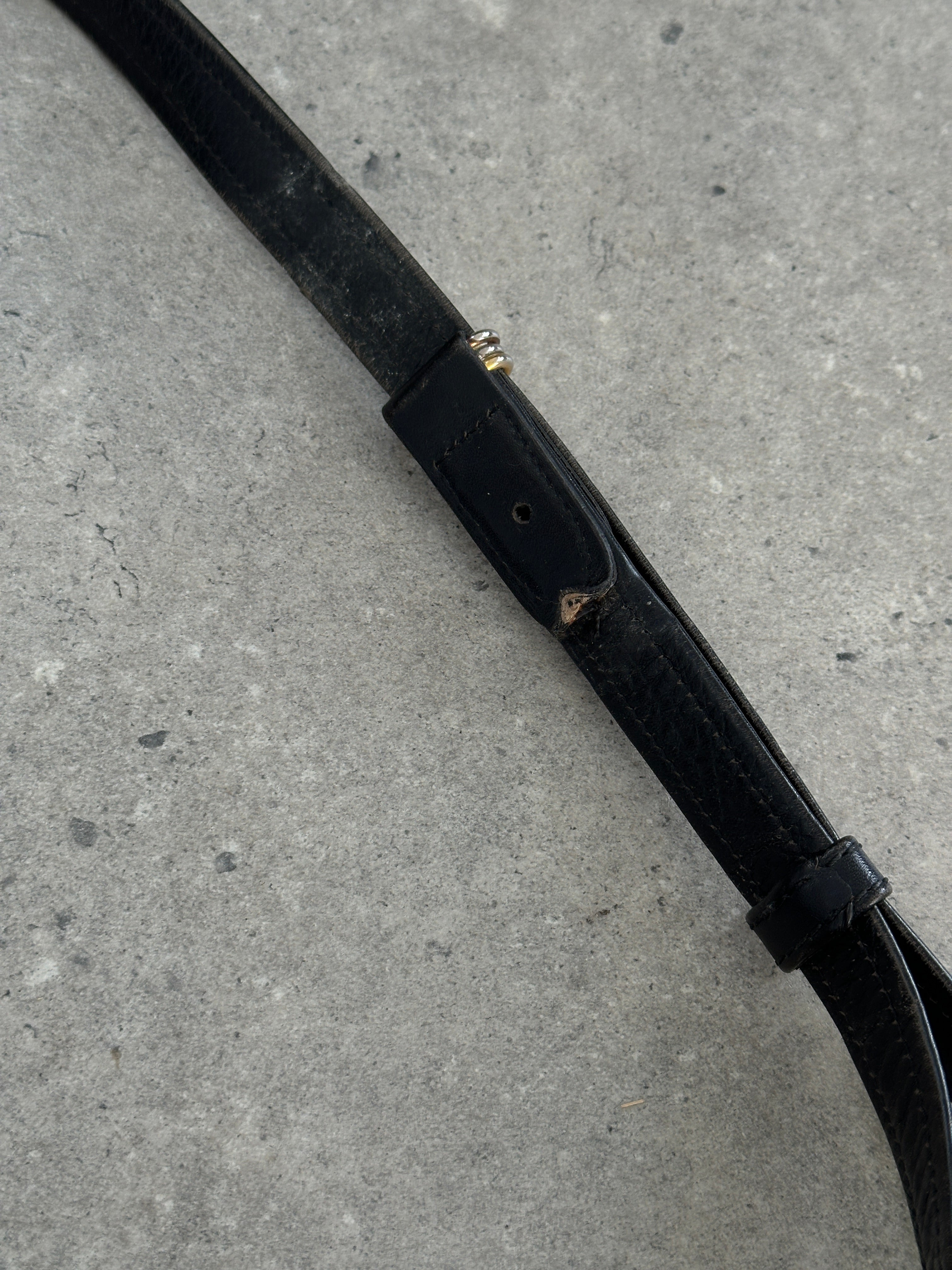 Cartier 1980s leather bucket bag with gold-tone hardware and adjustable shoulder strap, featuring a textured leather finish.