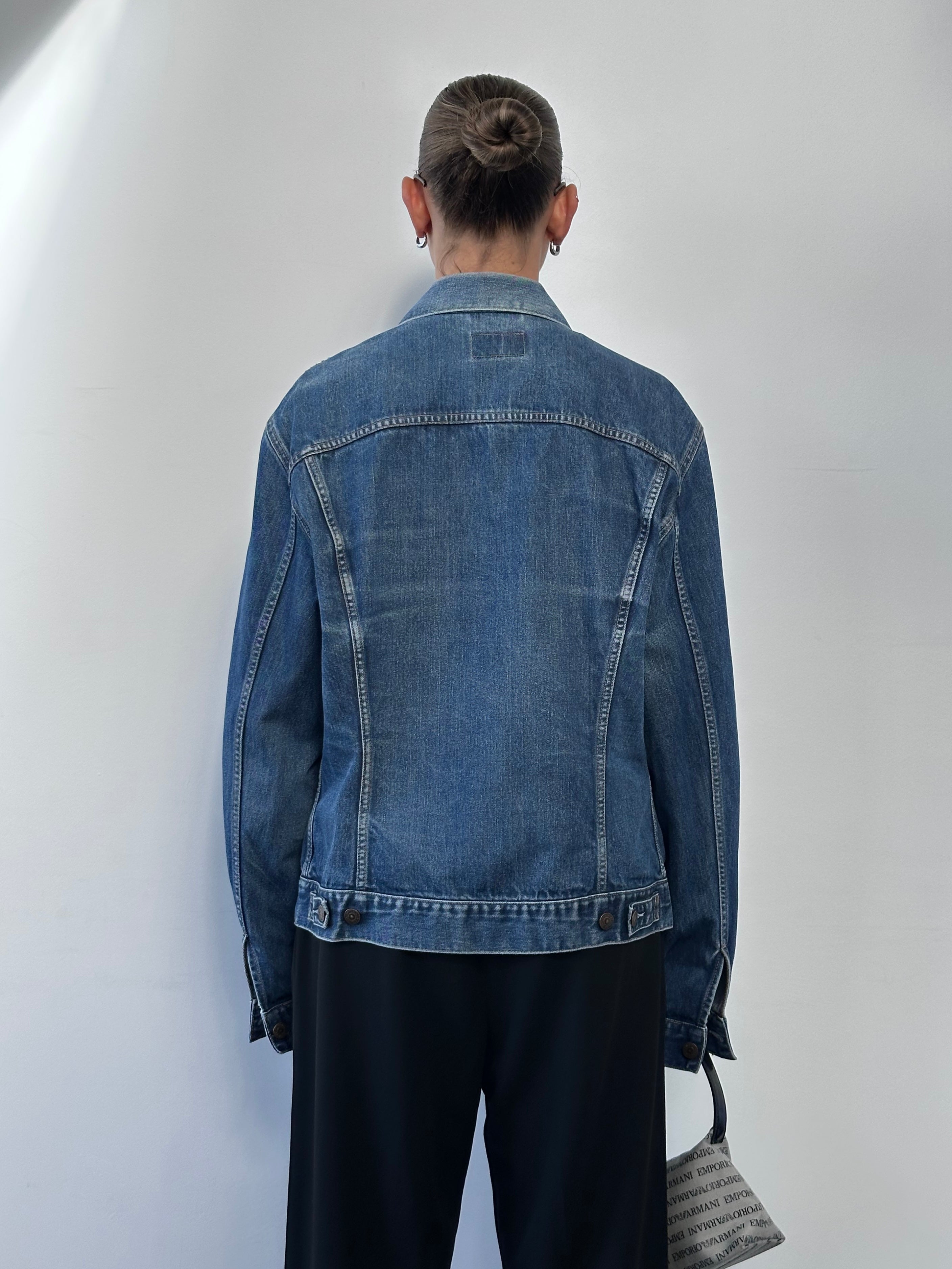 Levi’s faded denim jacket in size large, featuring a classic design with distressed details and metal button closures.