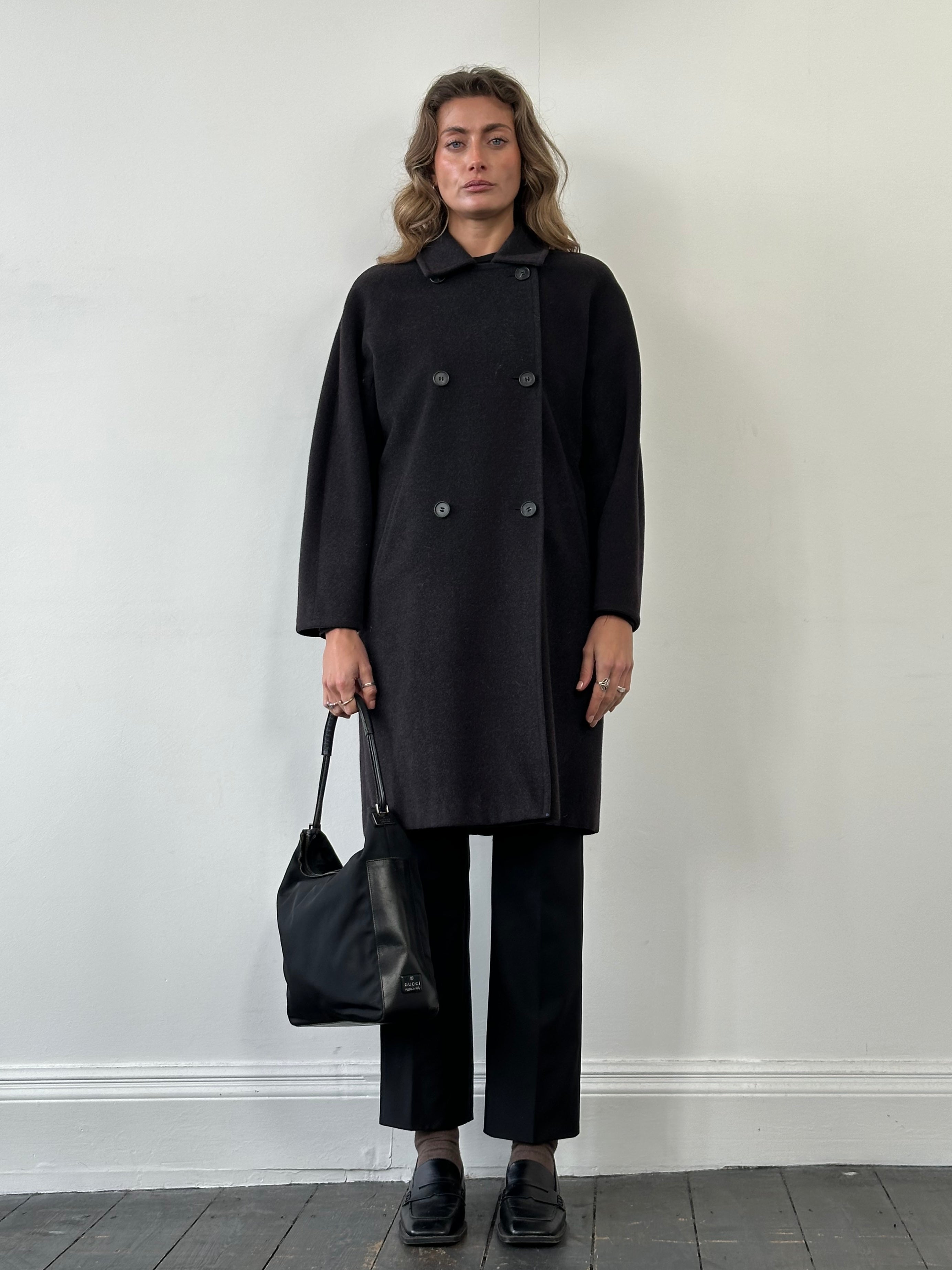 Max Mara pure wool double-breasted coat in size M, shown hanging on a hanger with a classic tailored design and neutral color.