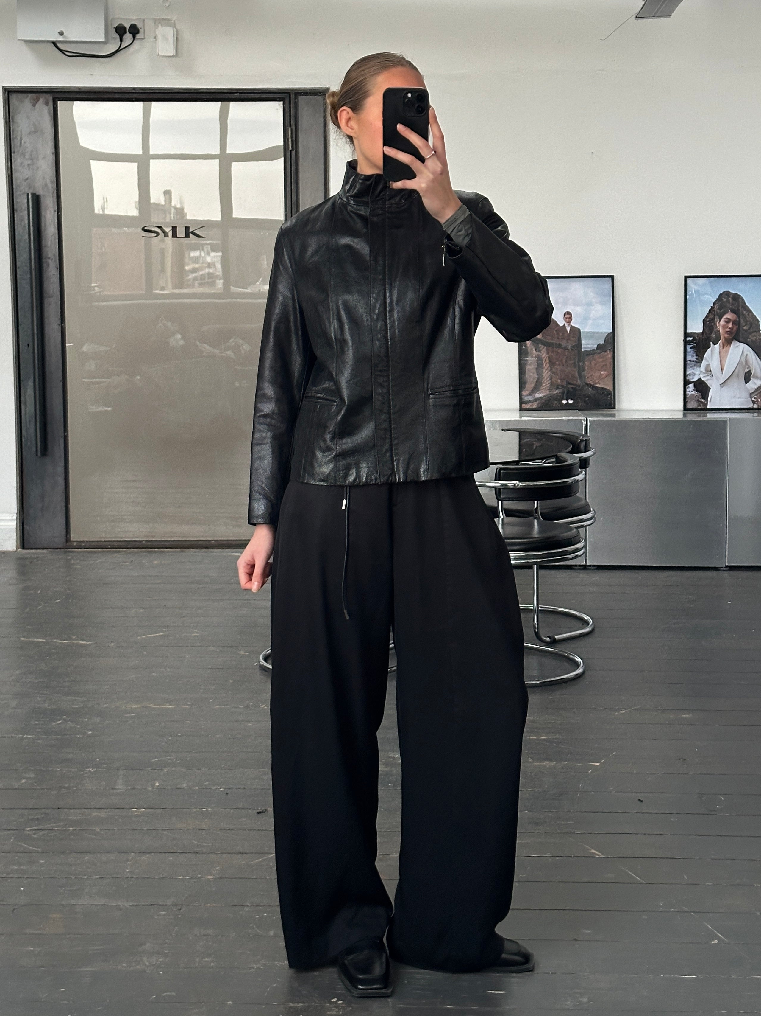 Vintage 1990s high neck leather jacket with double zippers, in black leather, featuring a classic retro style and fitted S/M size.